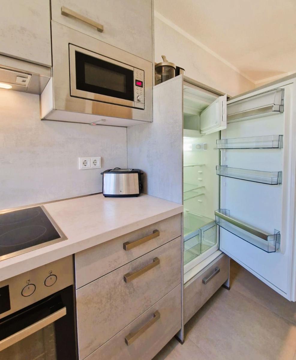 Küche mit Kühlschrank, Mikrowelle und Toaster.
