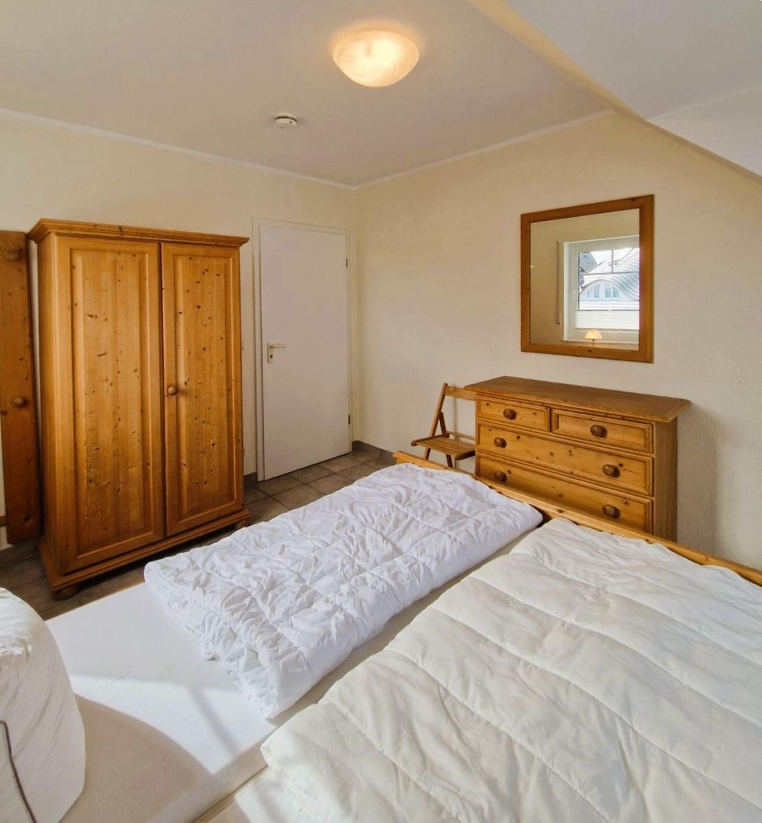 Schlafzimmer mit Bett, Kleiderschrank und Schminktisch
