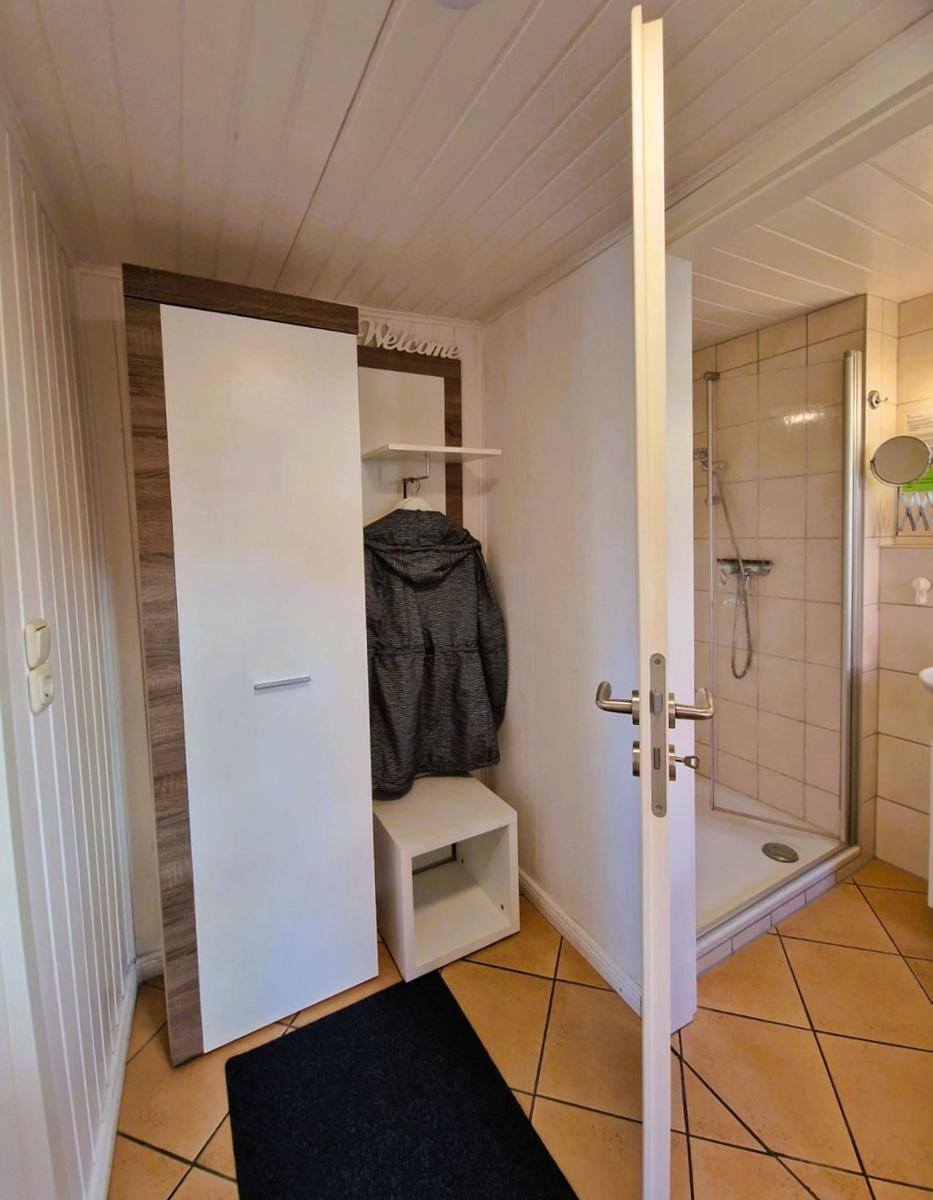 Hallway with closet and view into the shower