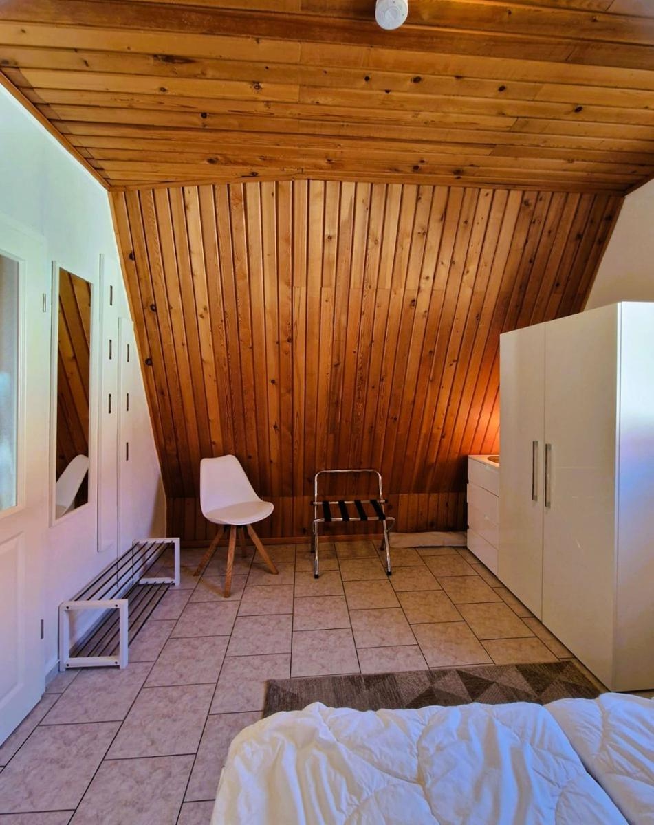 Bedroom with wooden ceiling, white closet, and bed in foreground.