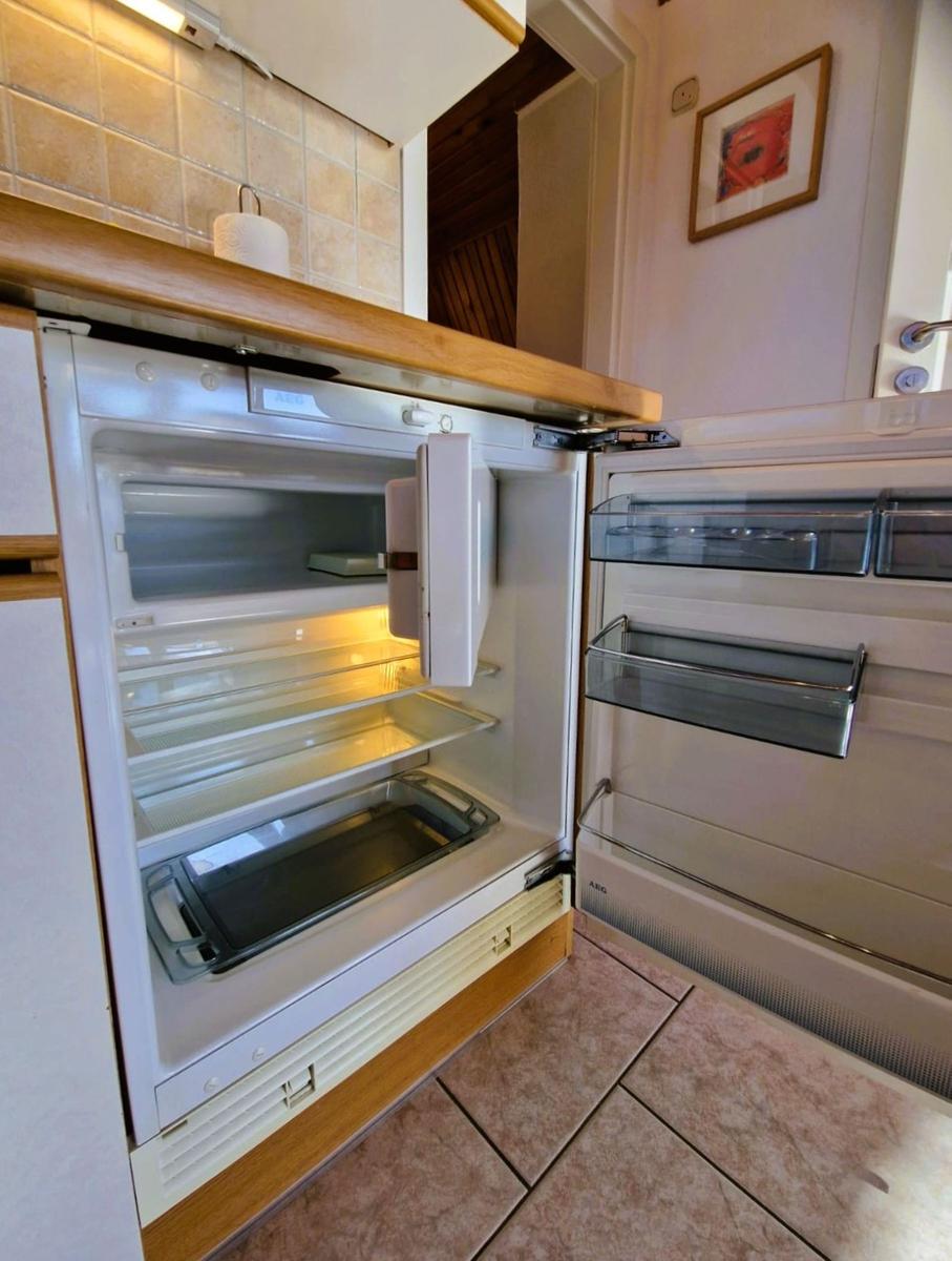 Refrigerator with open door and visible compartments in the kitchen