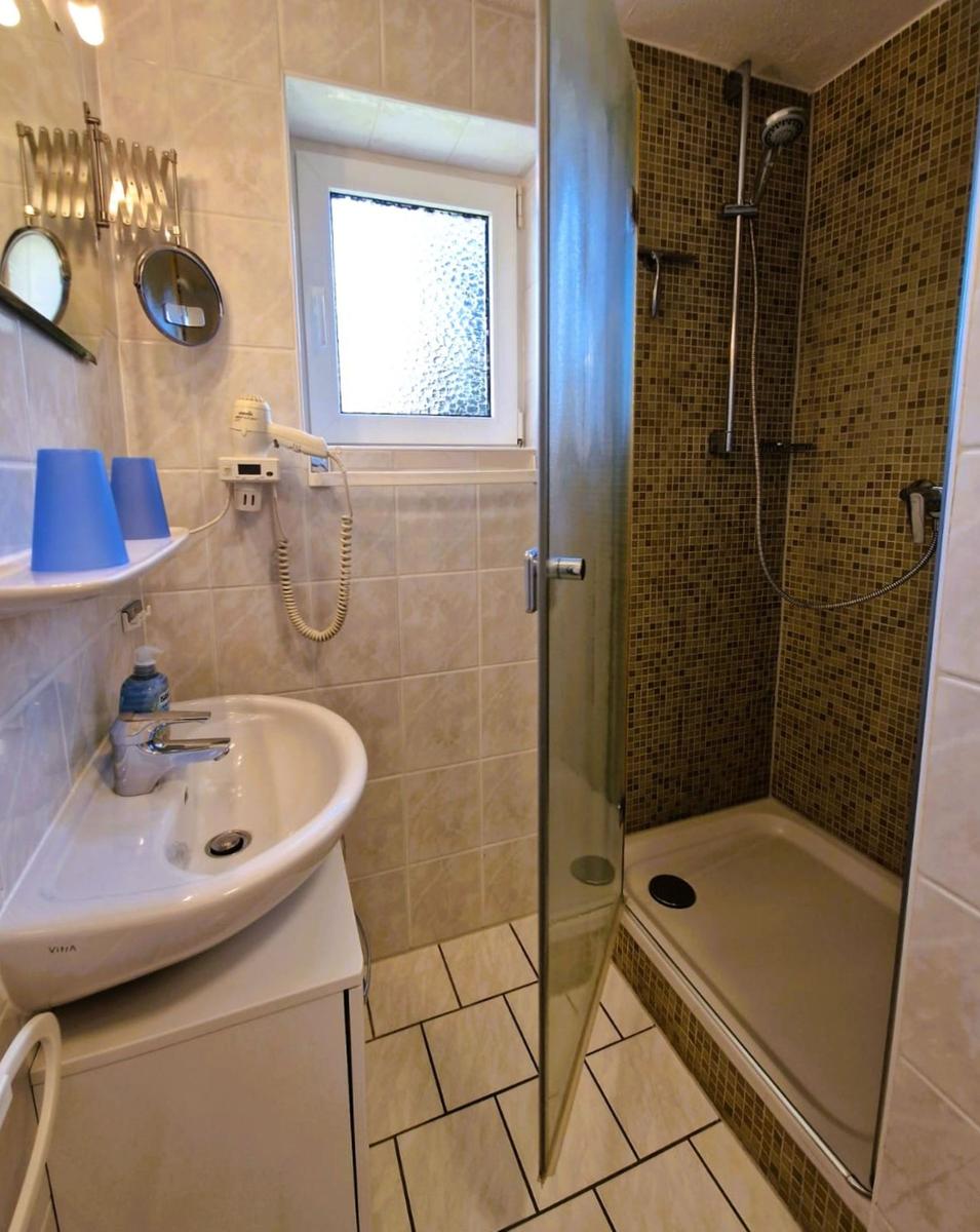 Bathroom with shower, sink, and window