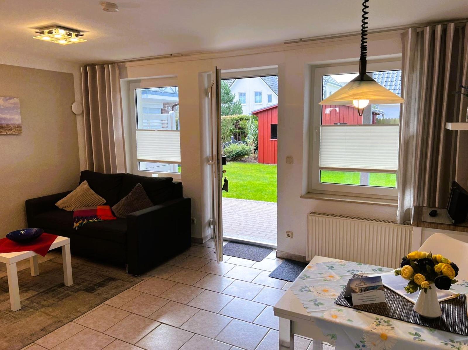 Living and dining area with view of garden and red shed.