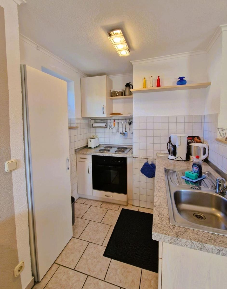 Kitchen with countertops, sink, stove, and refrigerator.