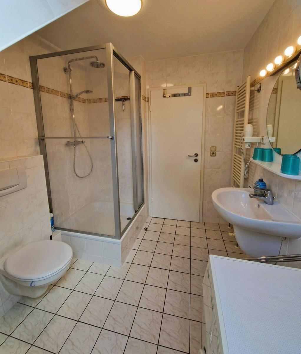 Badezimmer mit Dusche, Toilette und Waschbecken