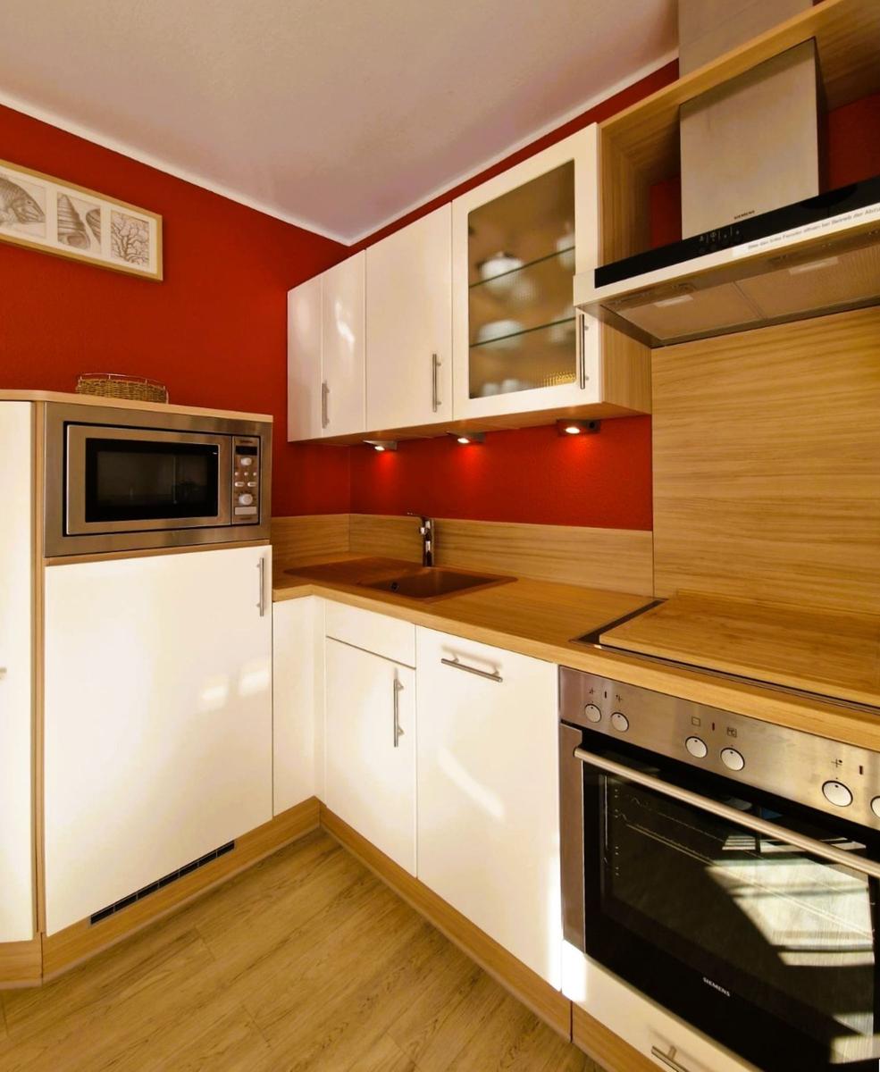 Kitchen with white cabinets, wooden surfaces, and integrated microwave.