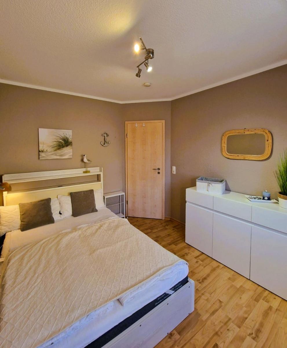Schlafzimmer mit Bett, Schrank und Holzboden