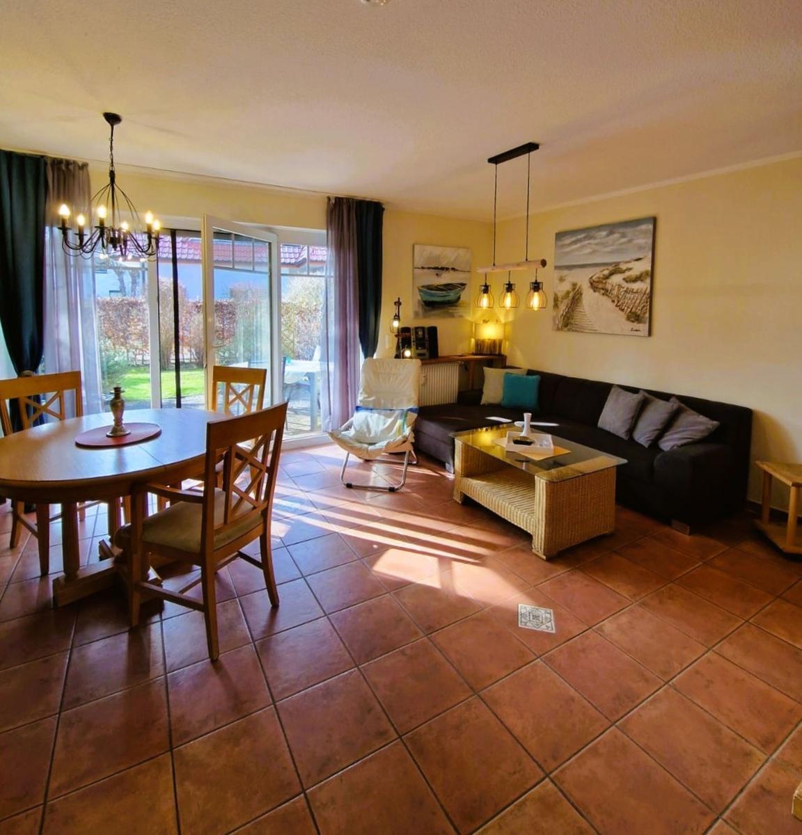 Wohn- und Essbereich mit Sofa, Esstisch und Terrassentür.