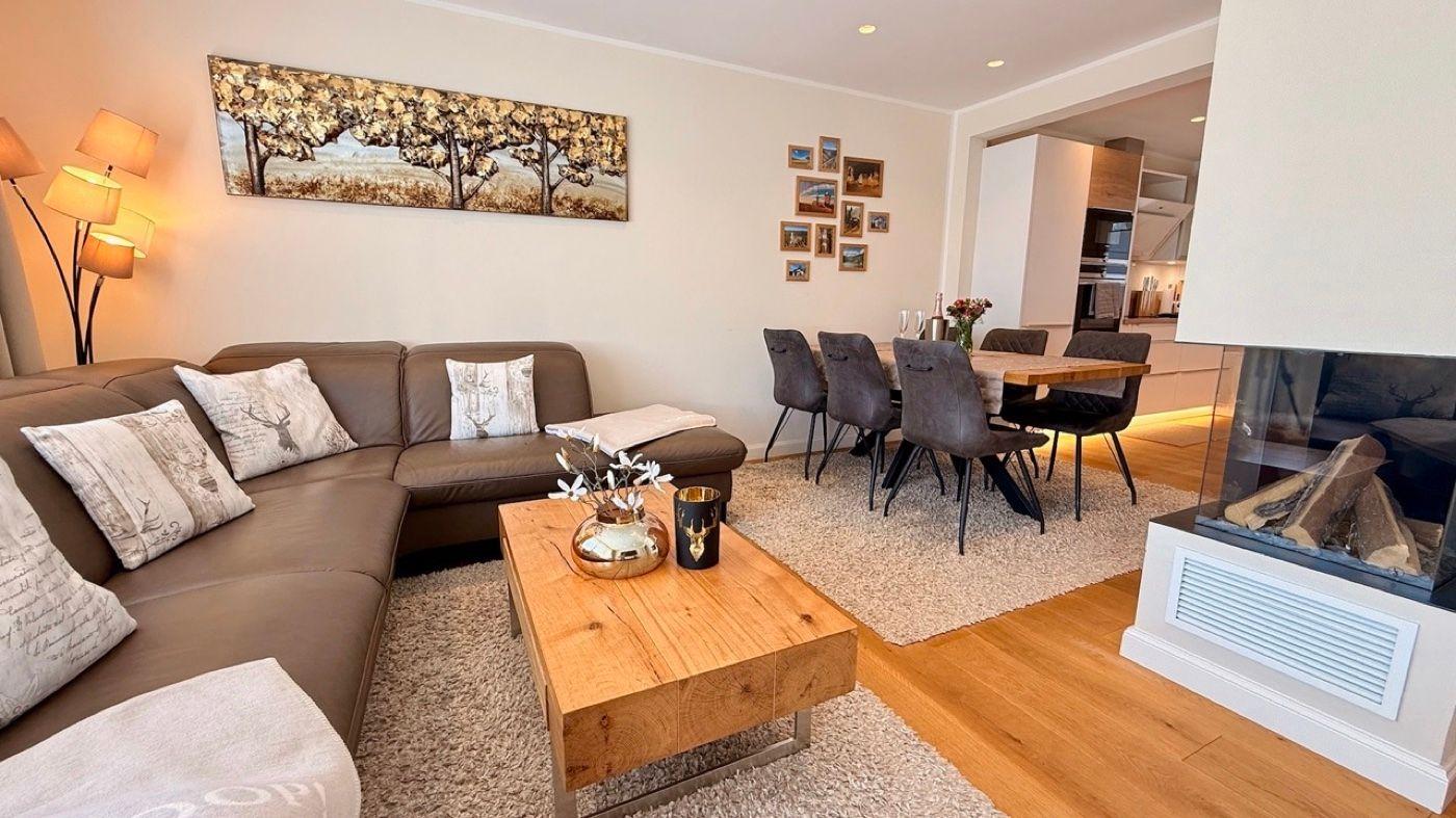 Wohn- und Essbereich mit Sofa, Esstisch und Kamin