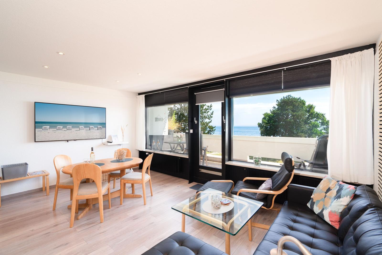 Wohnbereich mit Essbereich, Sofa und Blick auf den Strand.