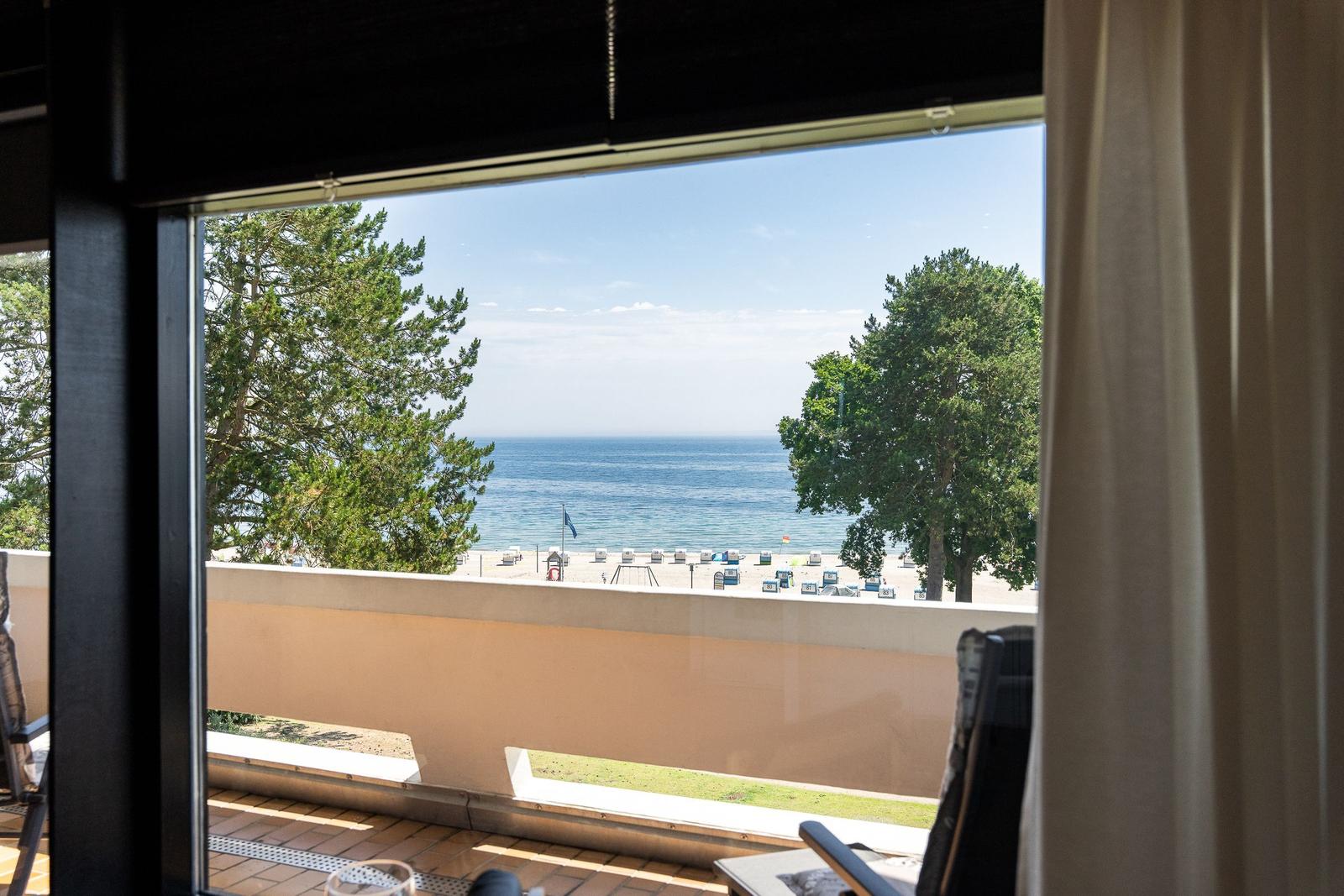 Von der Terrasse aus blickt man auf den Strand und das Meer.