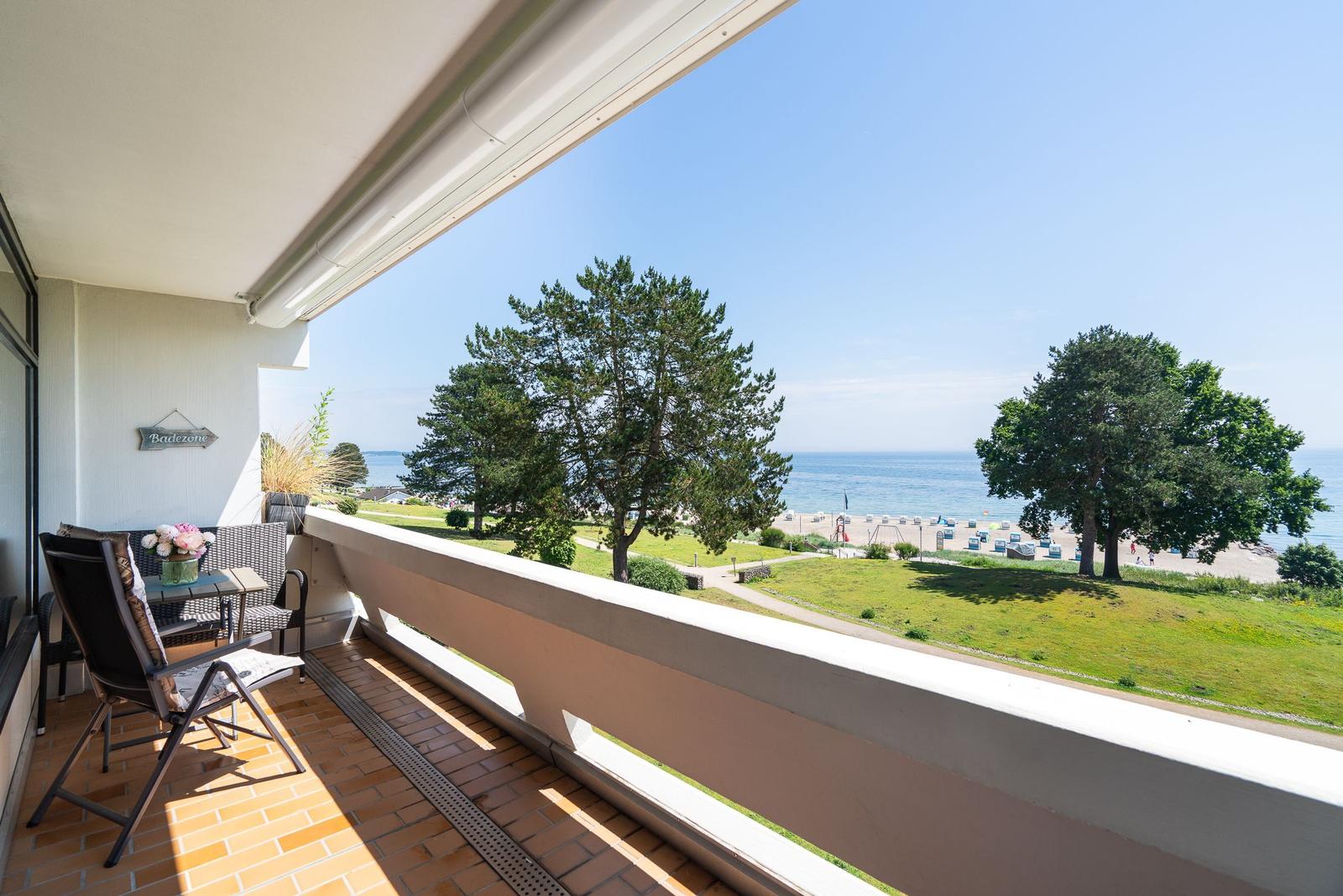 Terrasse mit Sitzgelegenheit und Blick auf Strand und Meer.