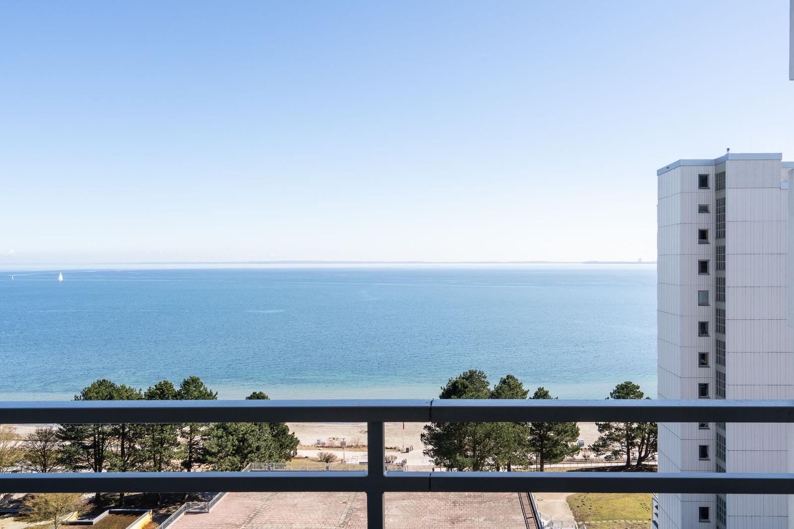 View from balcony over sea, beach, and high-rise building