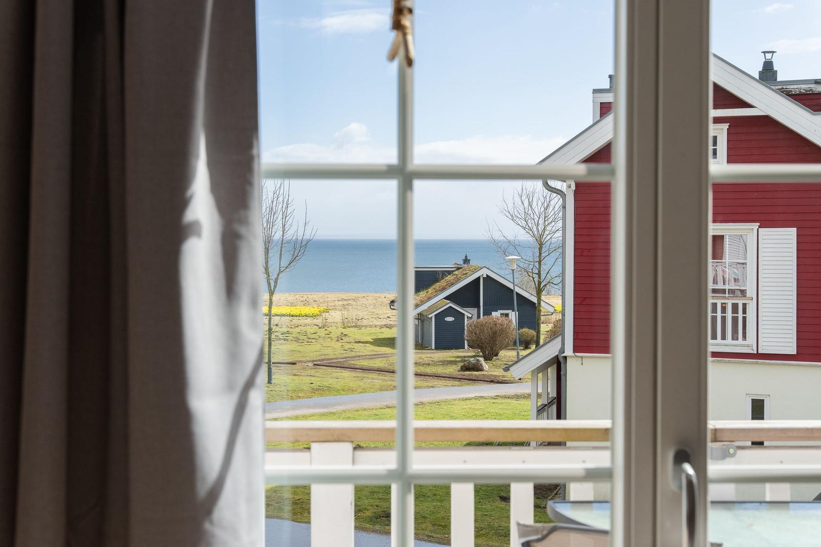 Blick vom Balkon auf das Meer und rote Häuser