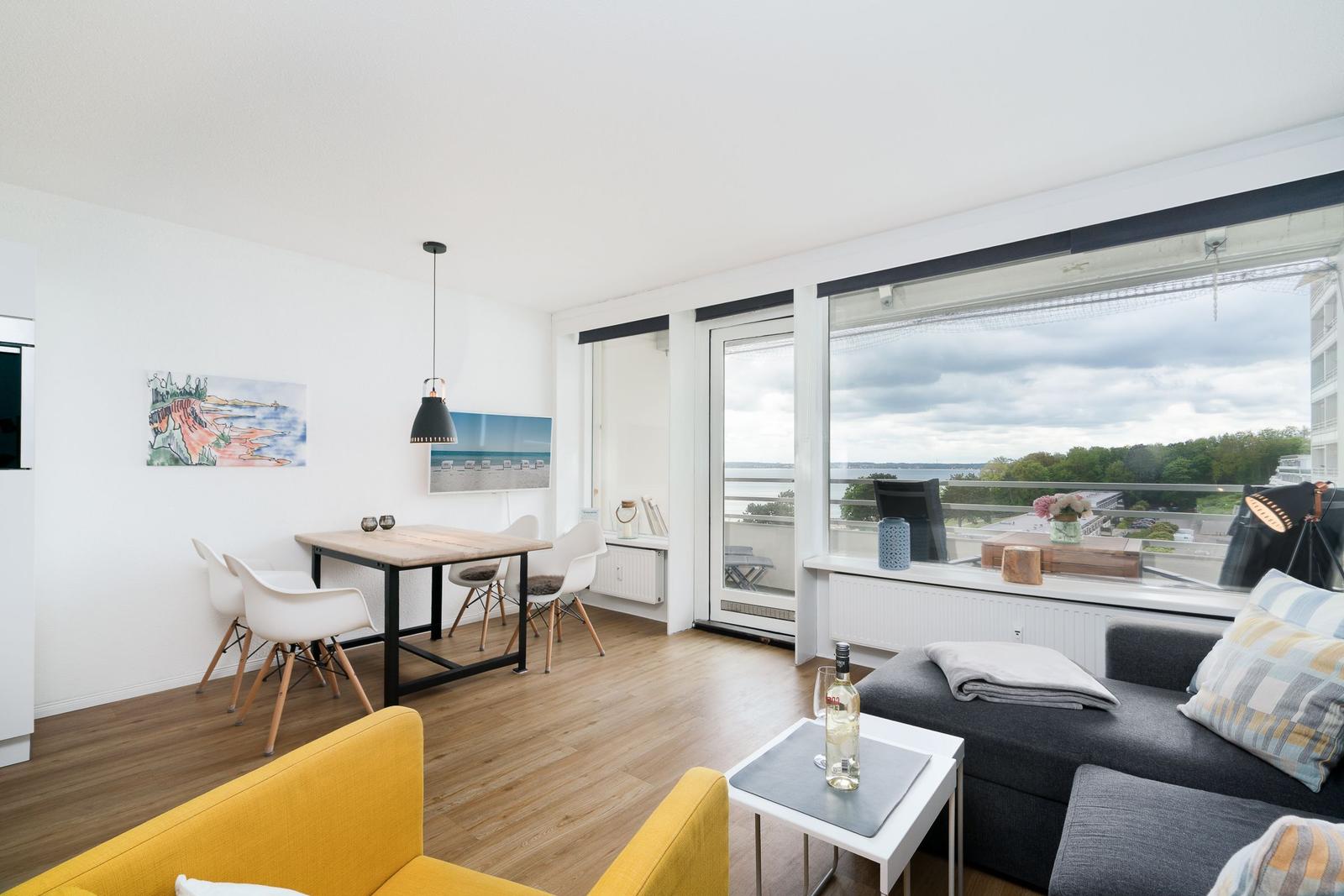 Wohnbereich mit Essbereich, Sofa und großem Fenster mit Aussicht.