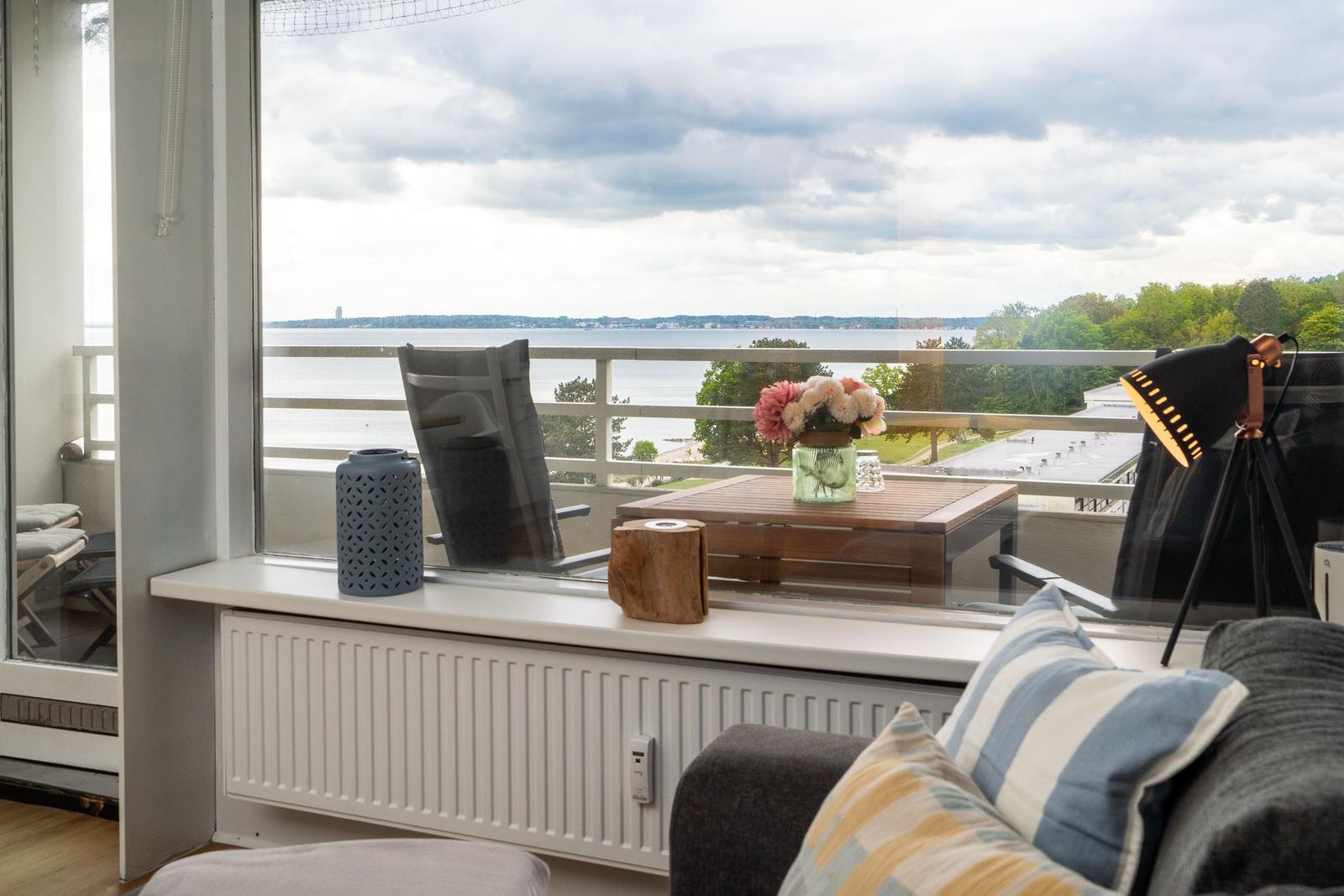 Blick auf den See vom Balkon mit Tisch und Stühlen.