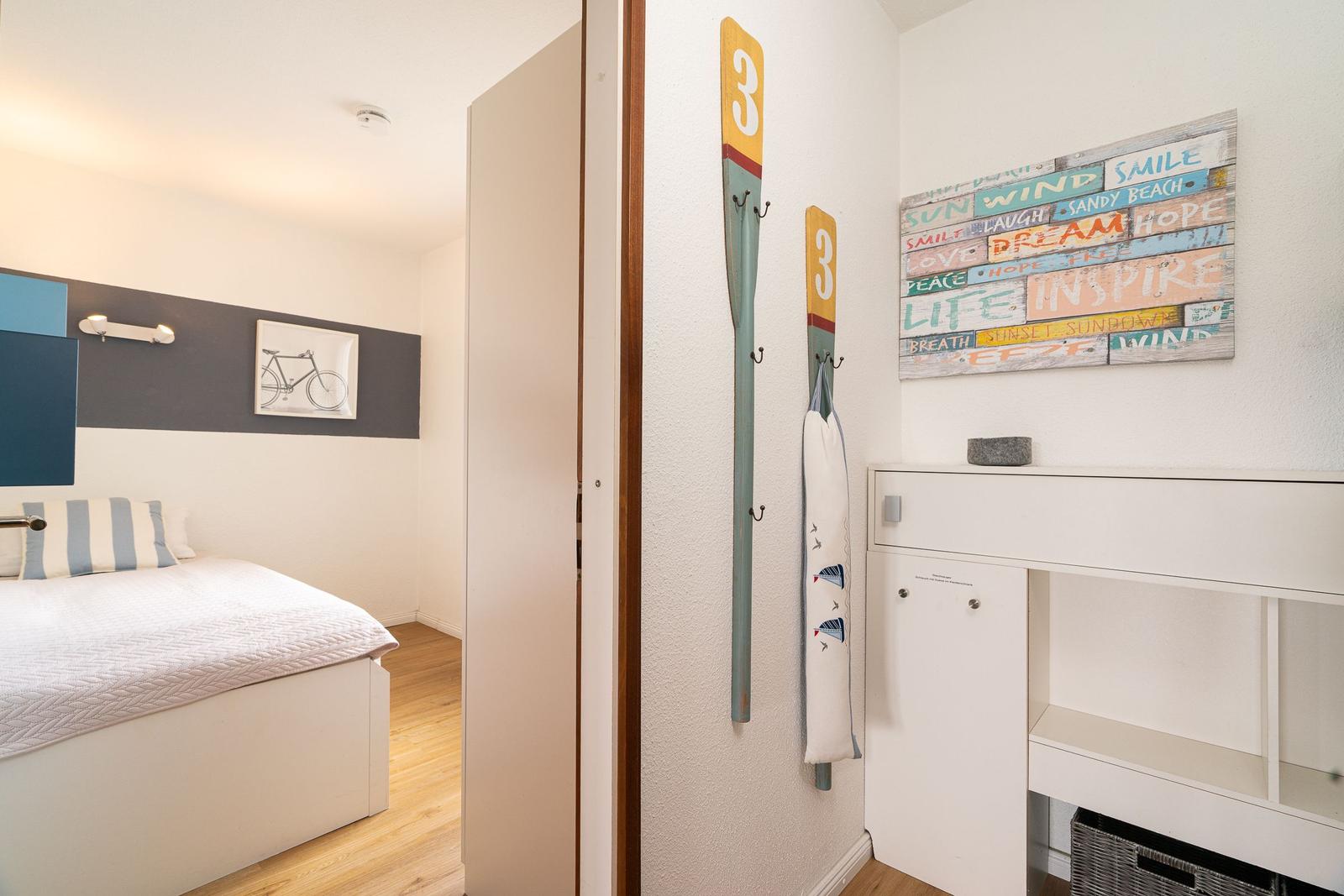 Schlafzimmer mit Bett, Wanddekoration und Kleiderständer