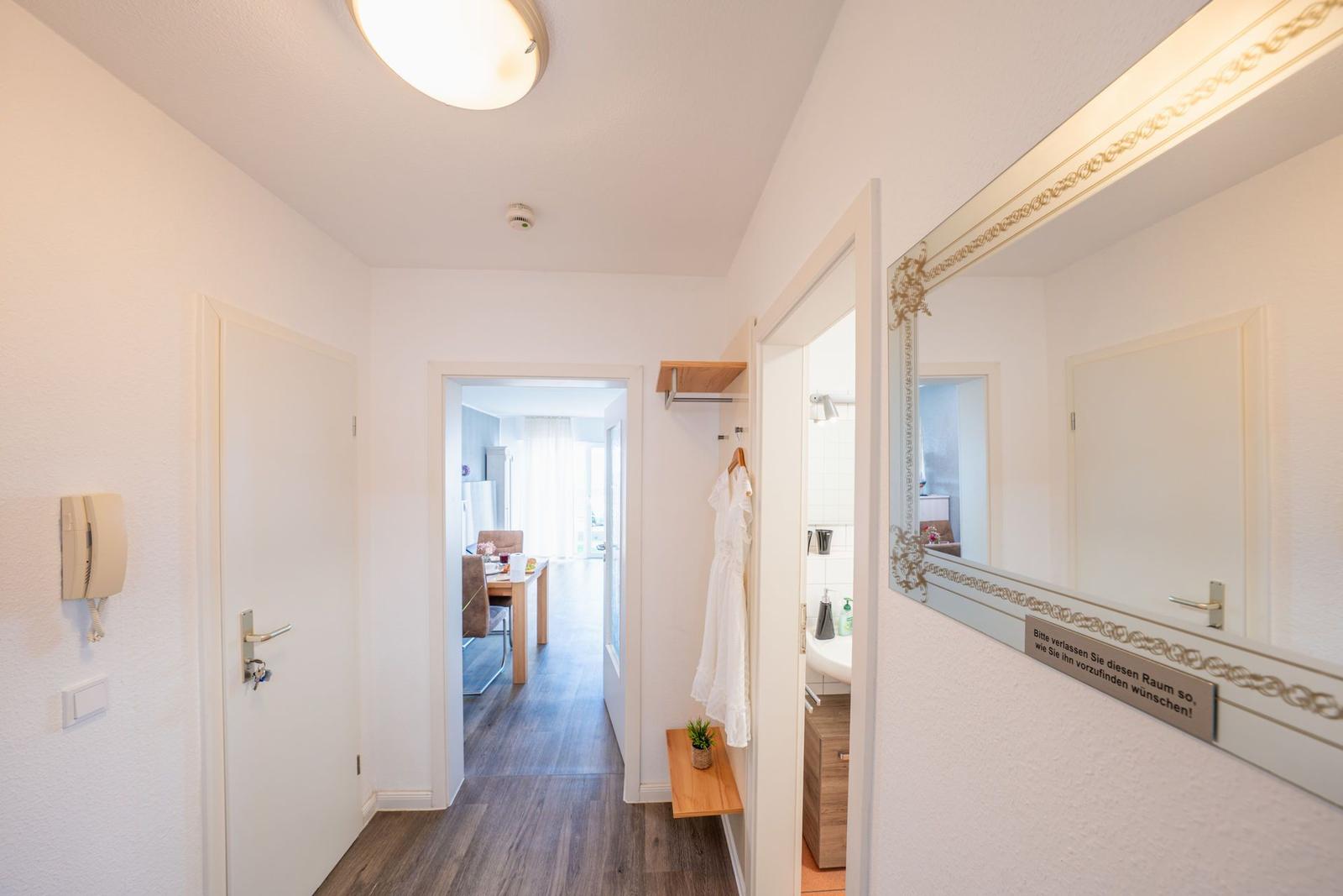 Flur mit Spiegel, Garderobe und Blick in Esszimmer und Bad