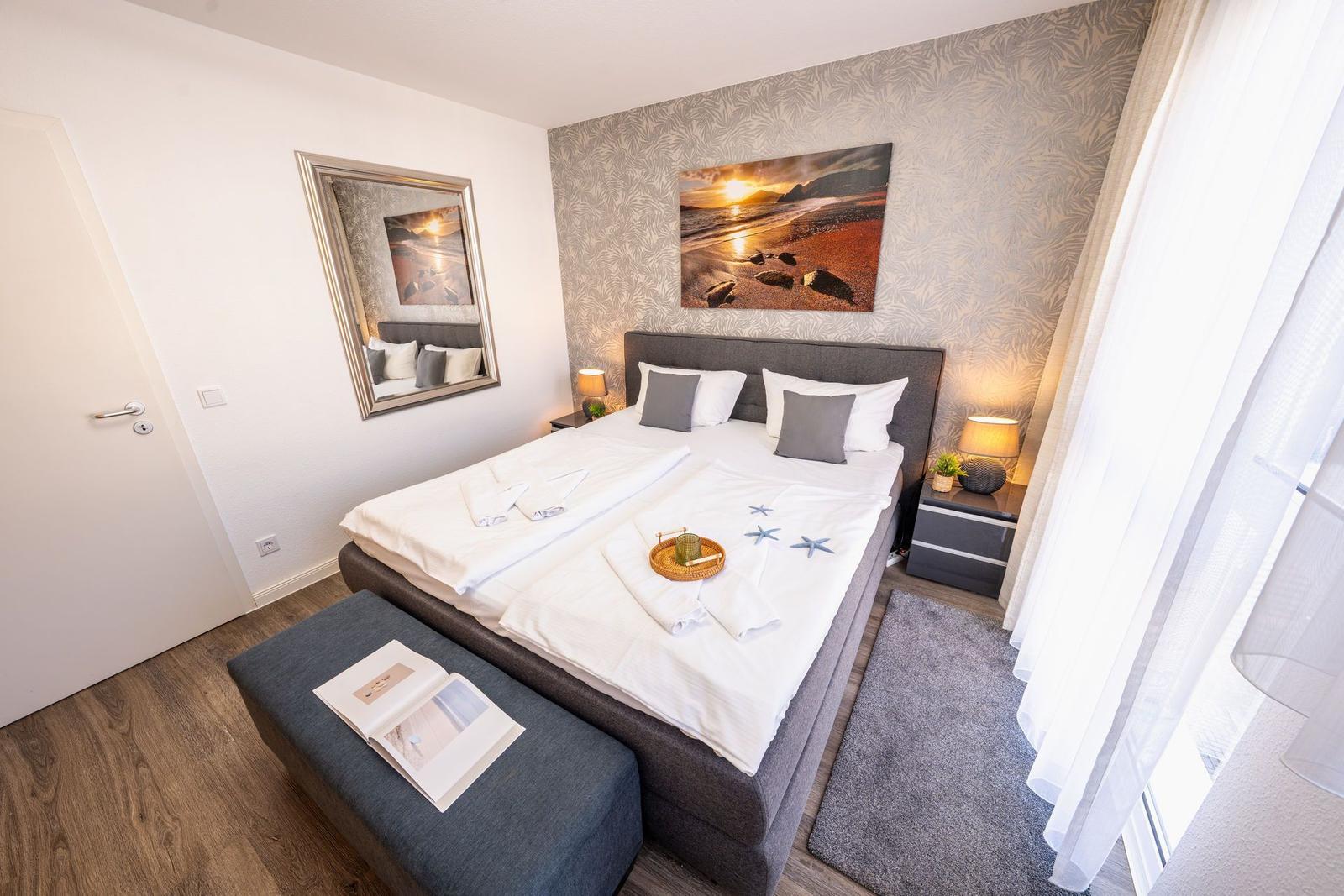 Schlafzimmer mit Bett, Wandbild und Nachttischen