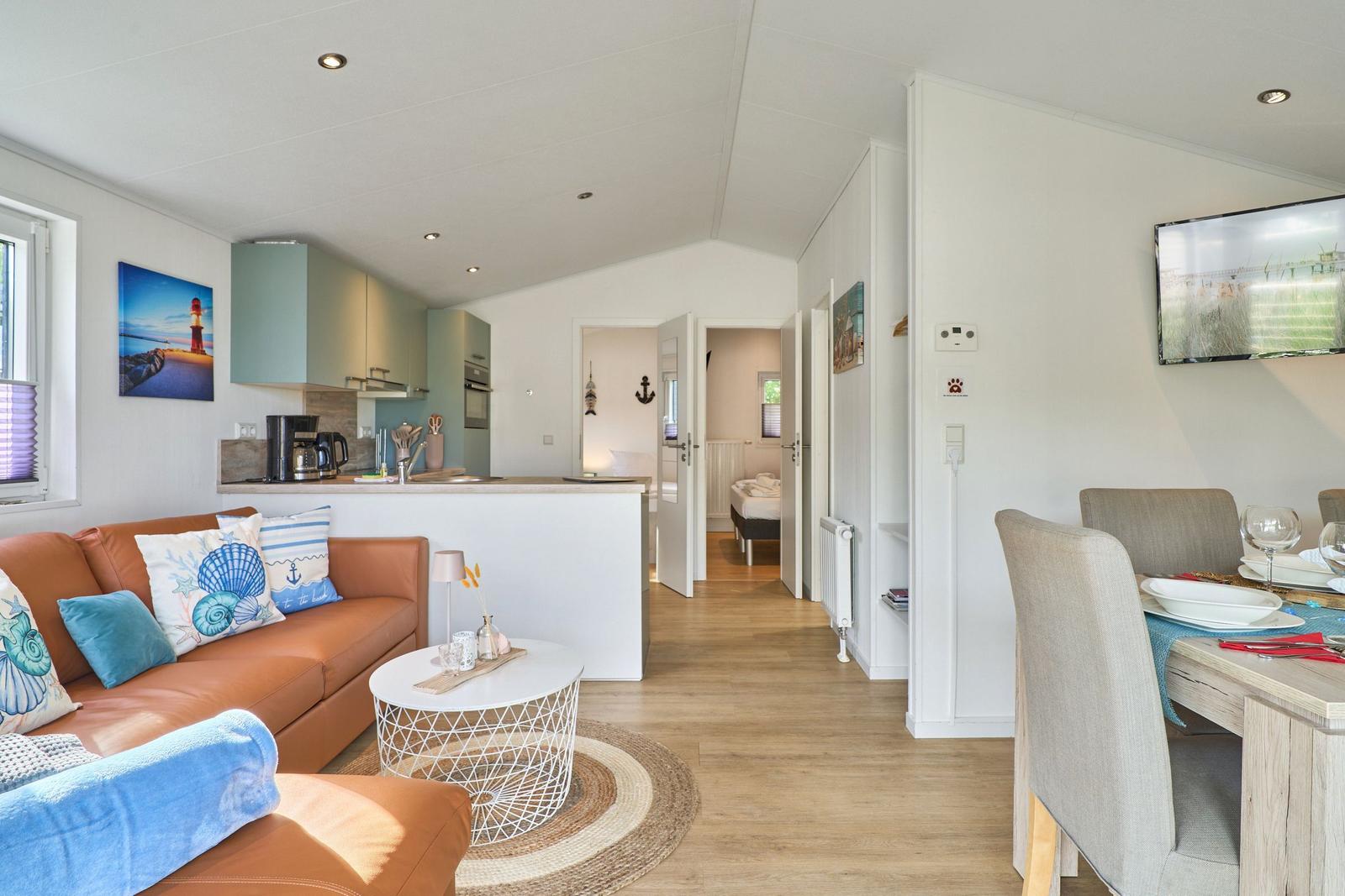 Wohnung mit Wohn- und Essbereich, Küche und Schlafzimmer im Hintergrund.
