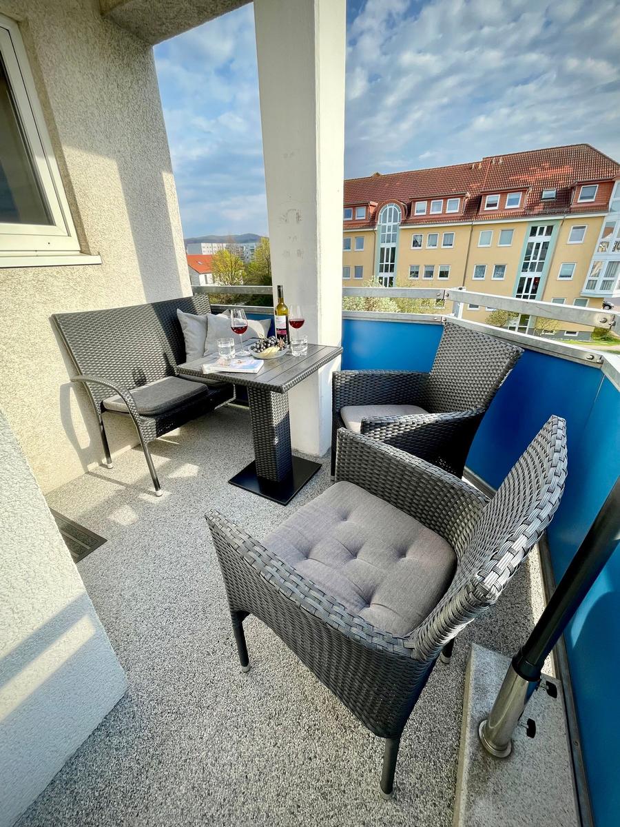 Terrasse mit Sitzgruppe, Tisch und Blick auf Gebäude.