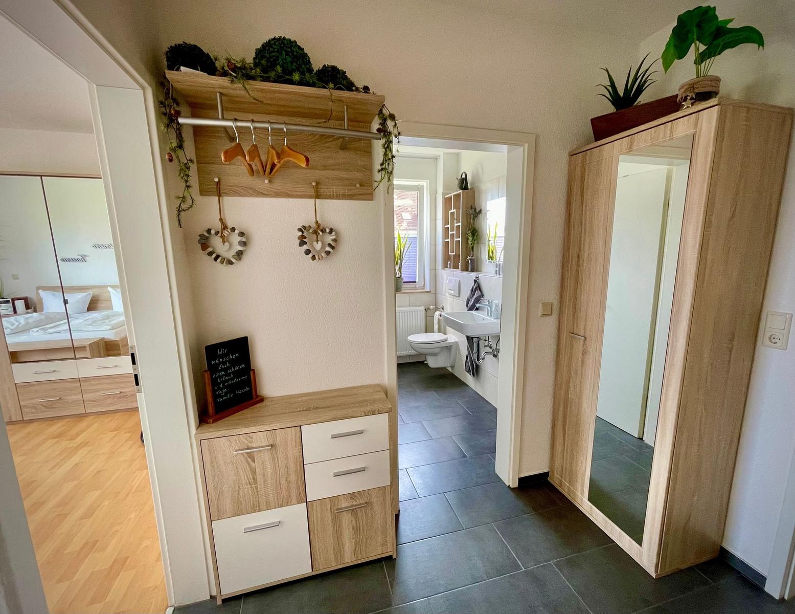 Flur mit Kleiderschrank, Garderobe und Blick in Schlafzimmer und Bad.