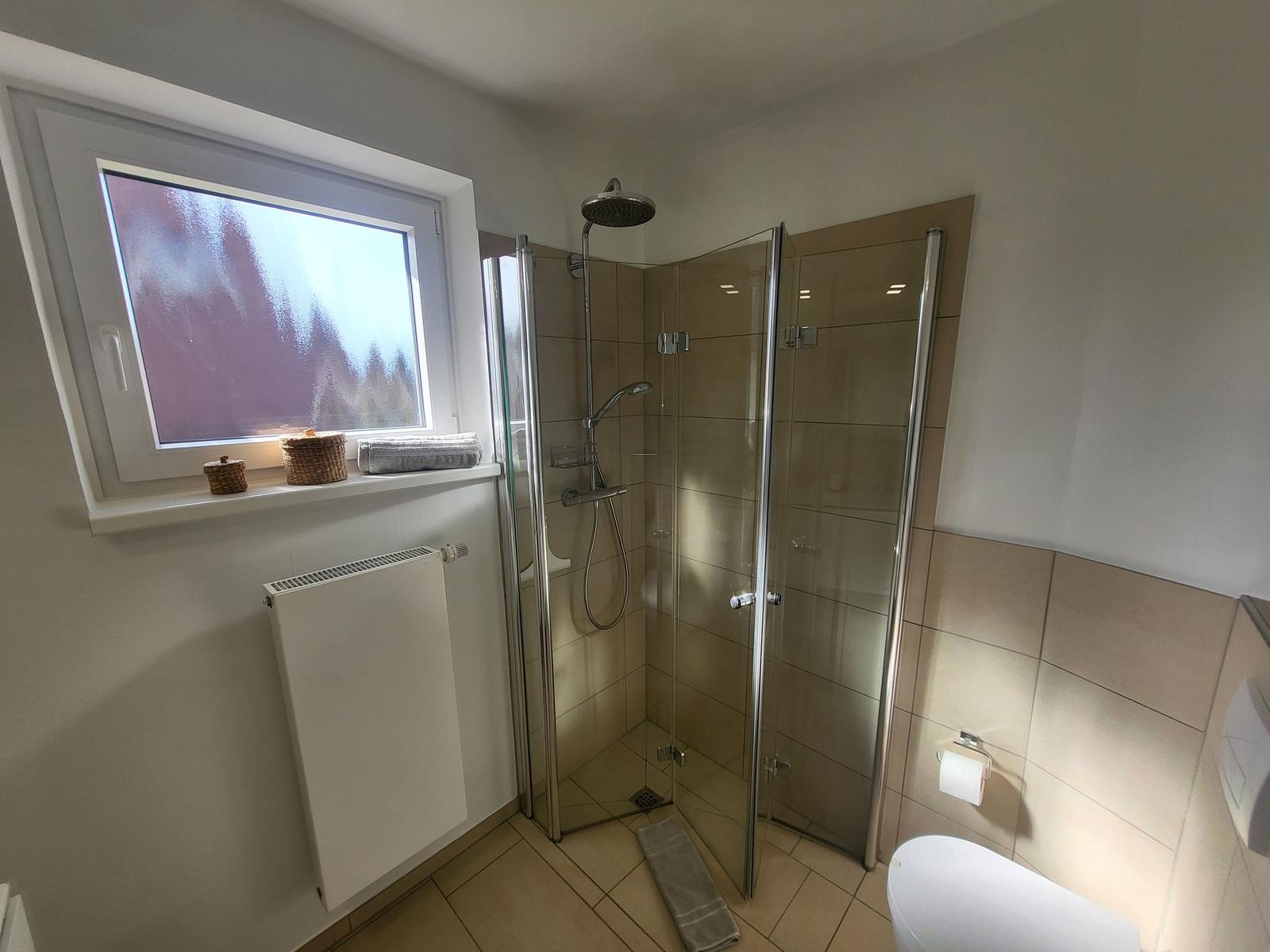 Bathroom with shower, window, and toilet