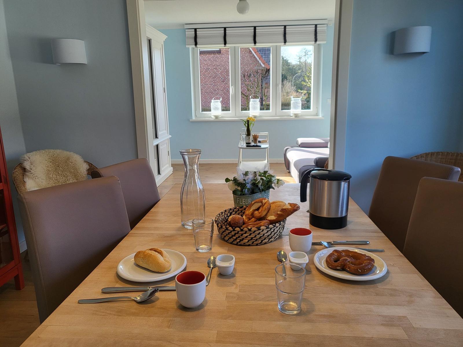 Dining table with breakfast items and view into living area.