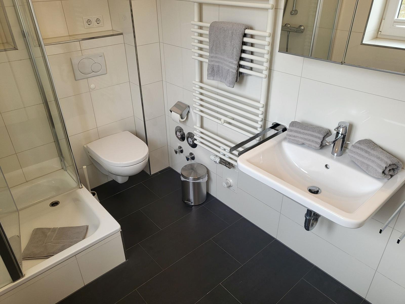 Badezimmer mit Dusche, Toilette und Waschbecken mit Handtüchern.