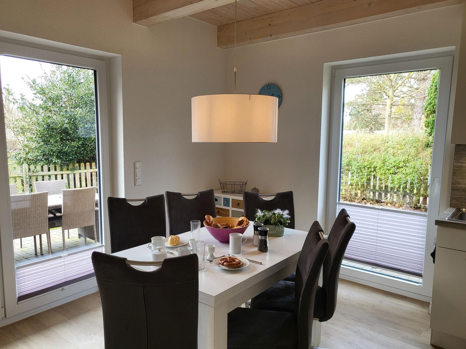 Esstisch mit sechs Stühlen, Blick auf Garten und Terrasse.