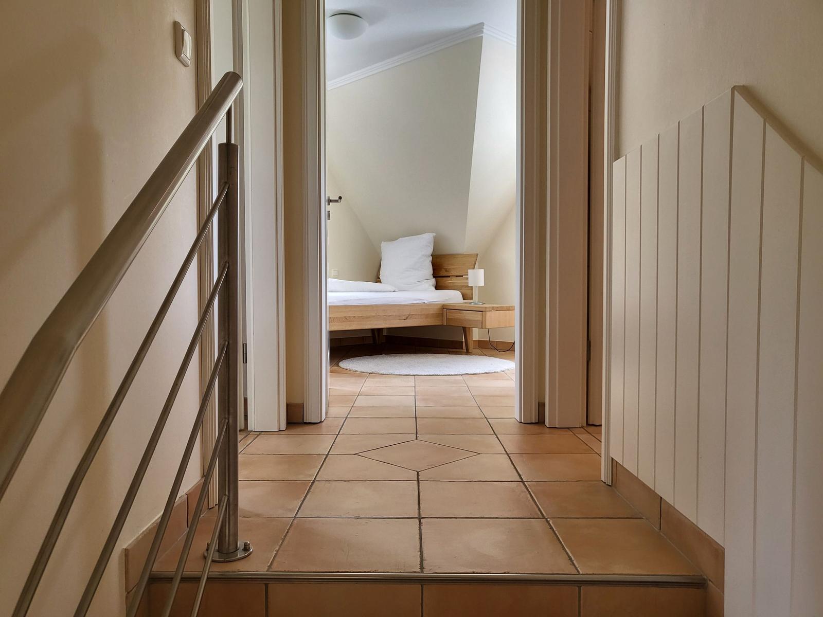 Durchgang zur Schlafzimmer mit Holzbett und Nachttisch