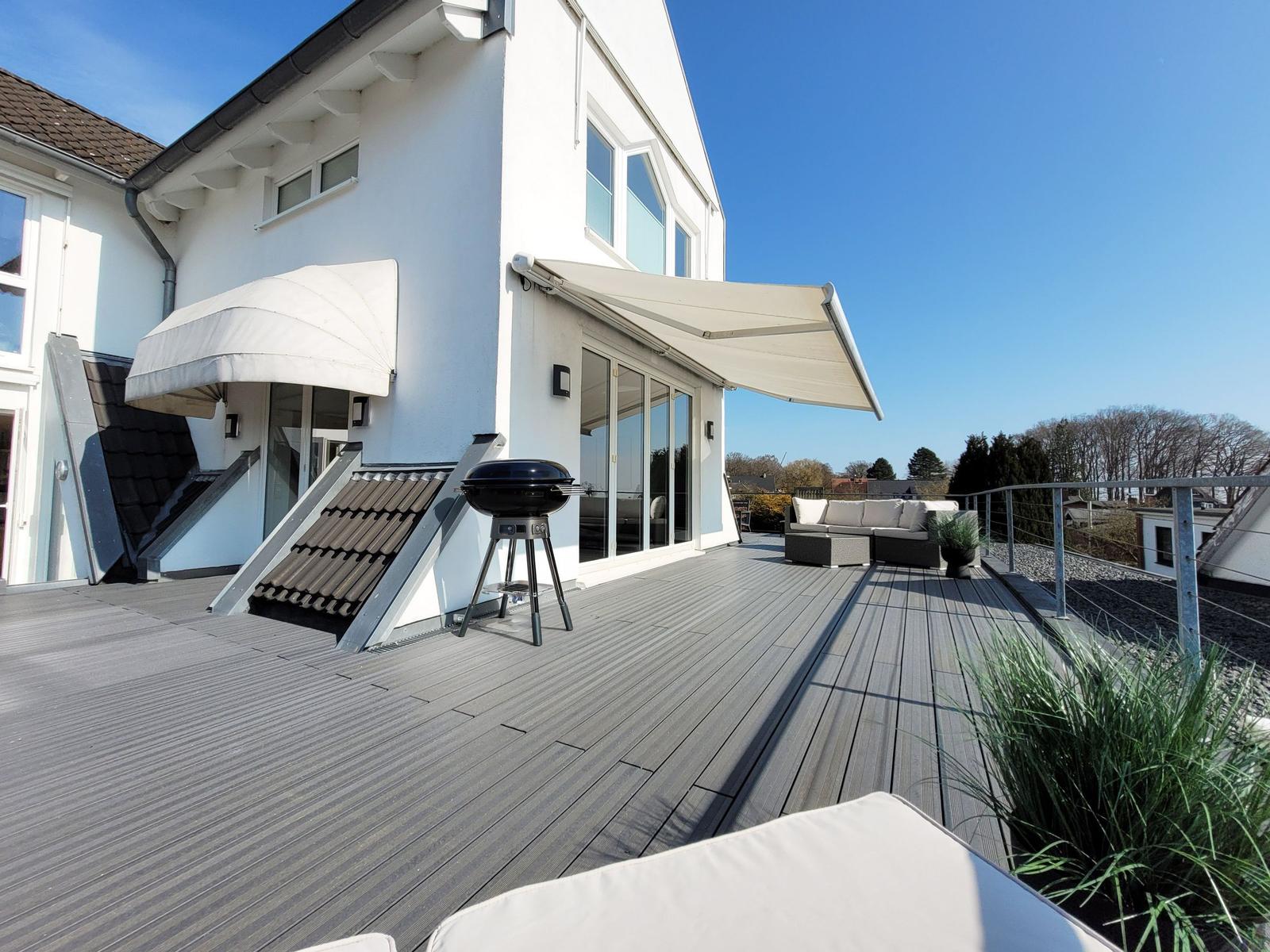 Große Sonnenterrasse mit Markise, Gartenmöbeln, Esstisch und Webergrill