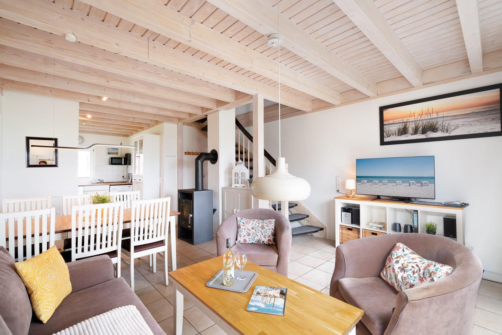 Living and dining area with wooden ceiling, sofa, table, and TV.
