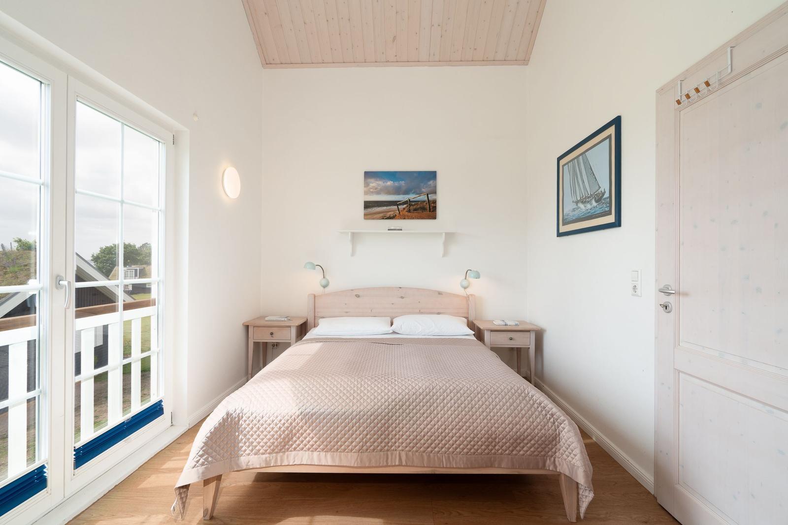Bedroom with bed, nightstands, and window to terrace.