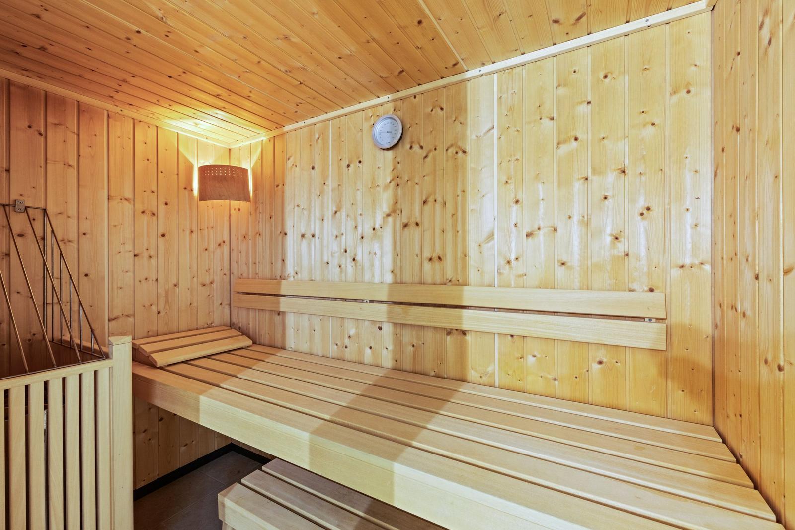 Holzsauna mit Sitzbänken und Wanduhr