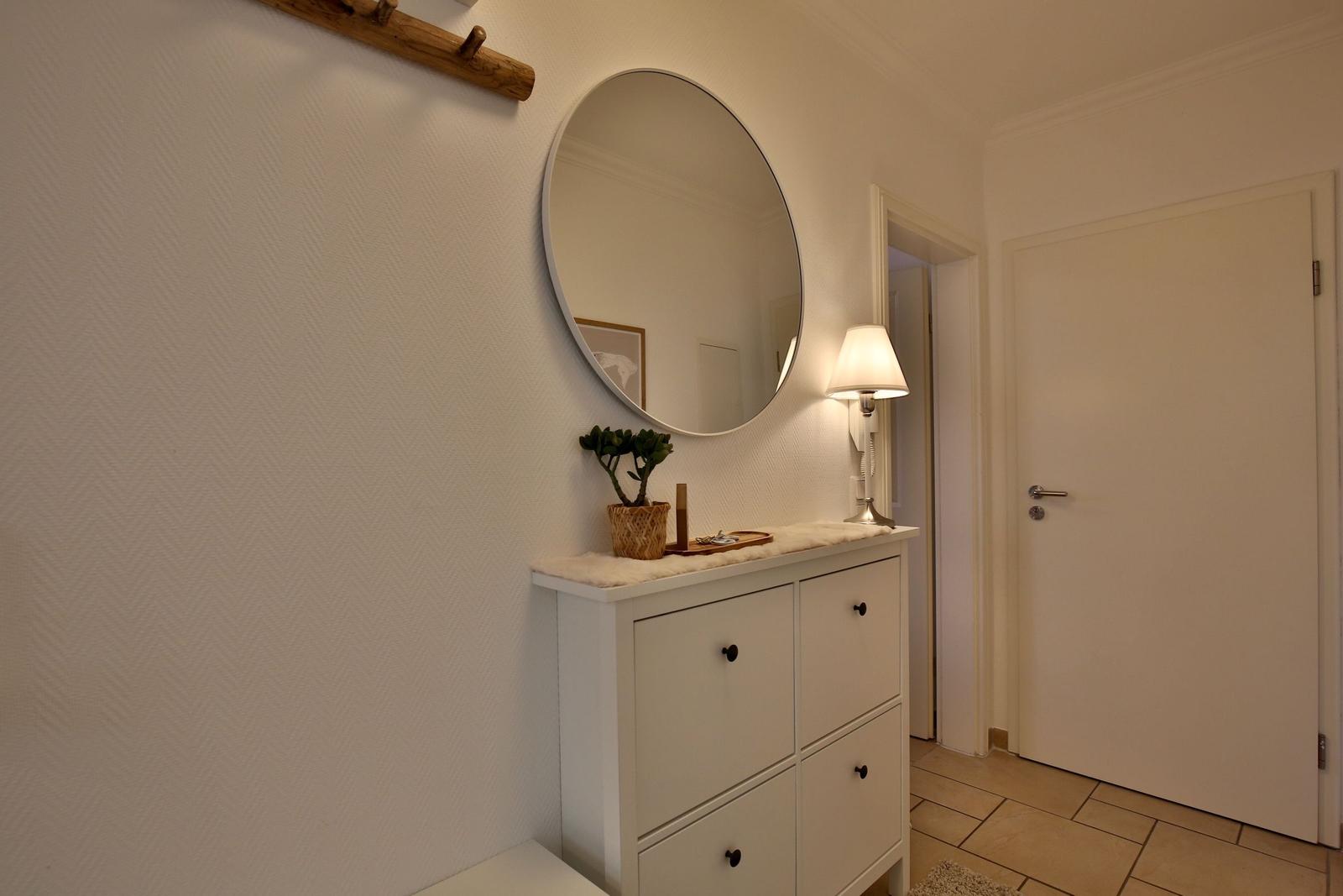 Entrance area with mirror cabinet, lamp, and plant.