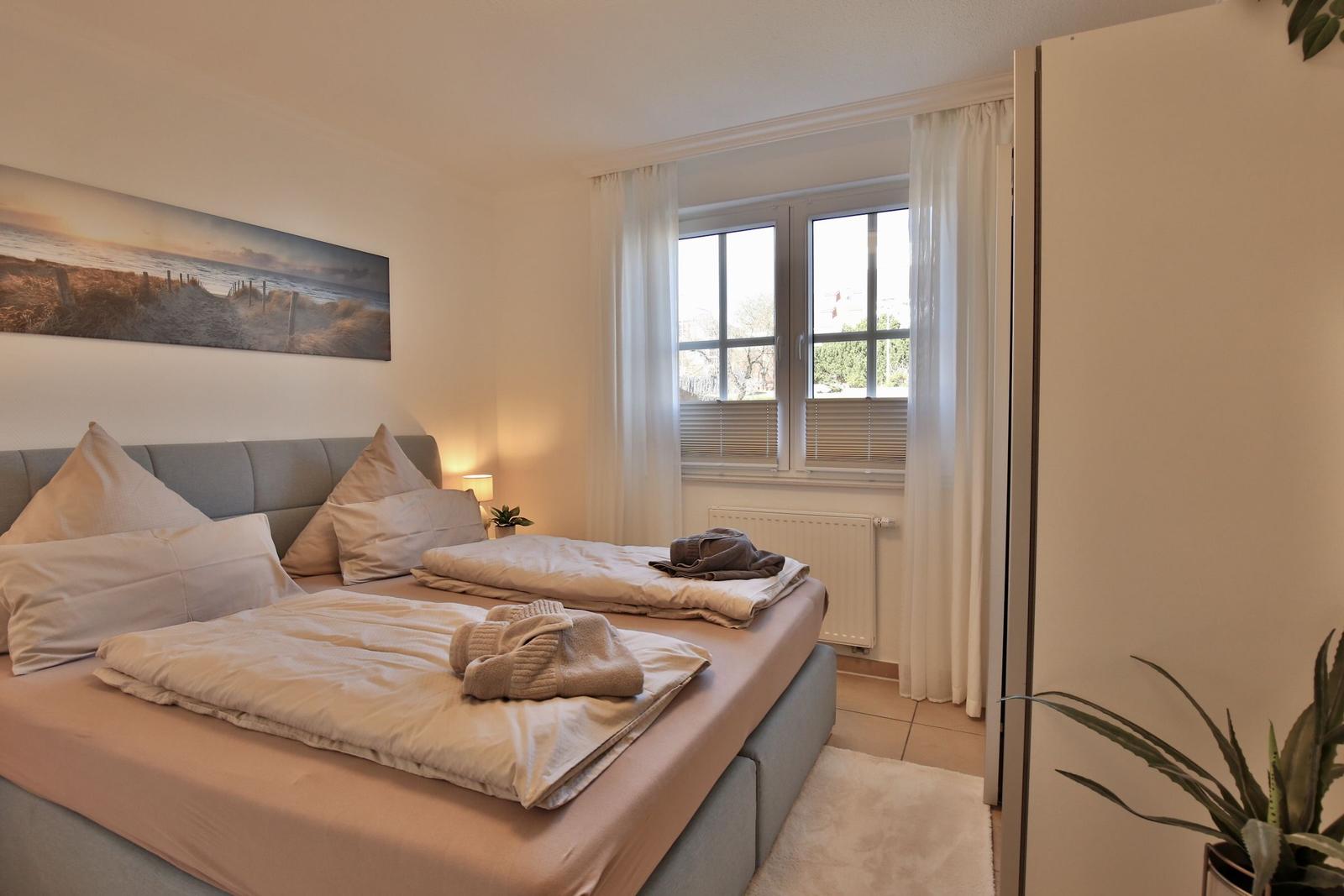 Bedroom with bed, window, and wall picture
