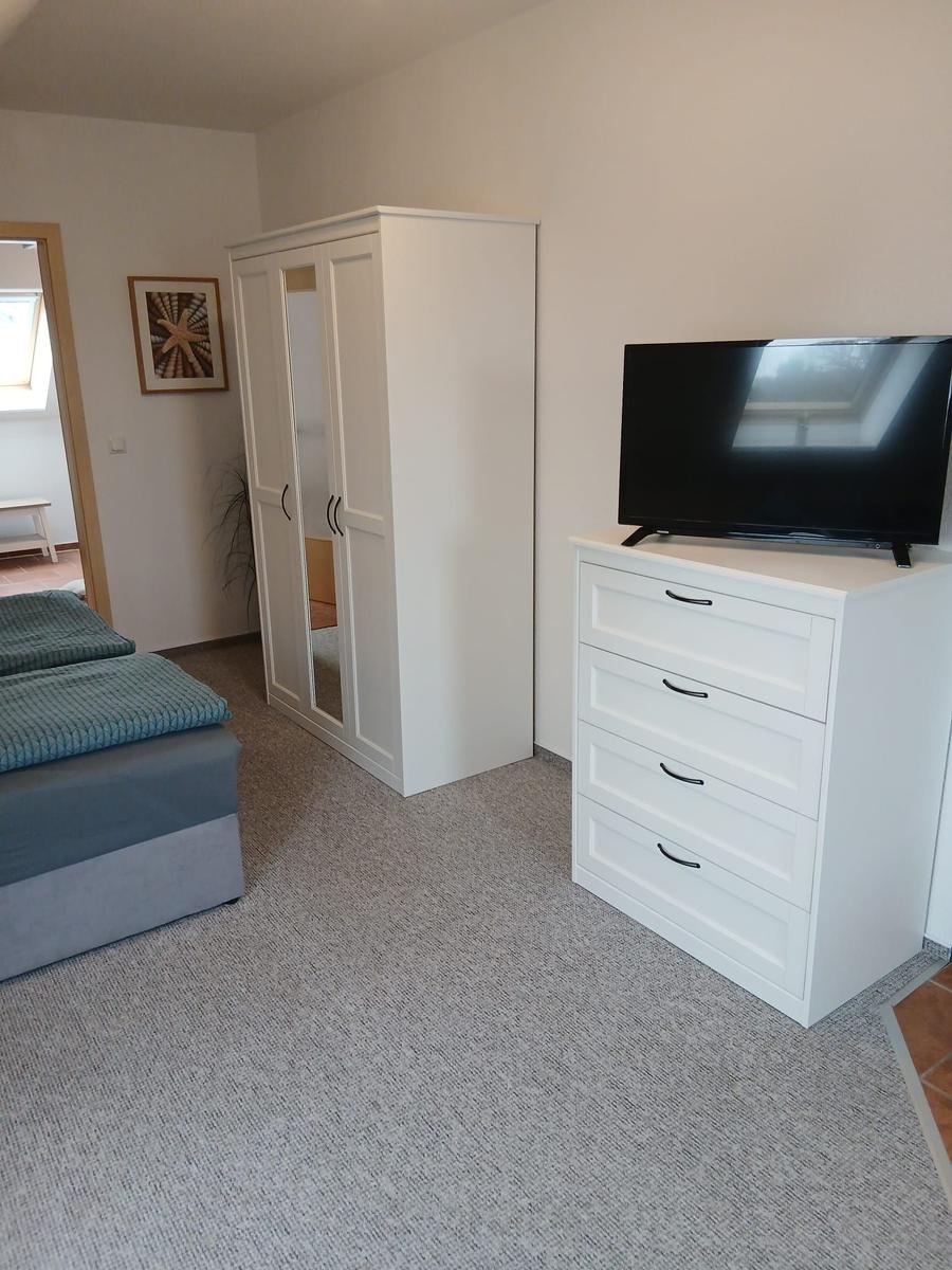 Schlafzimmer mit Bett, Kleiderschrank und TV-Schrank.