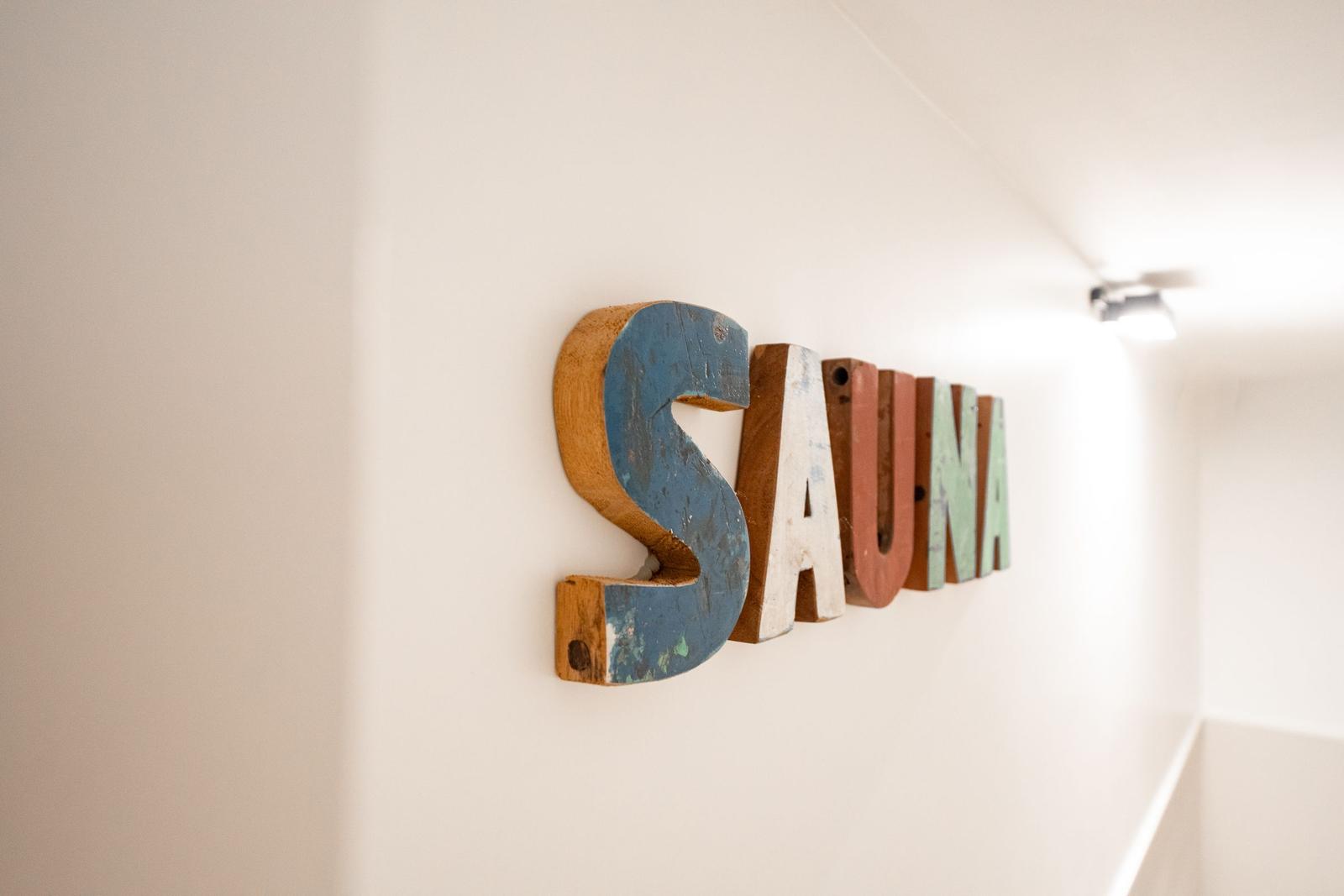 Wooden sign with the word SAUNA on the wall