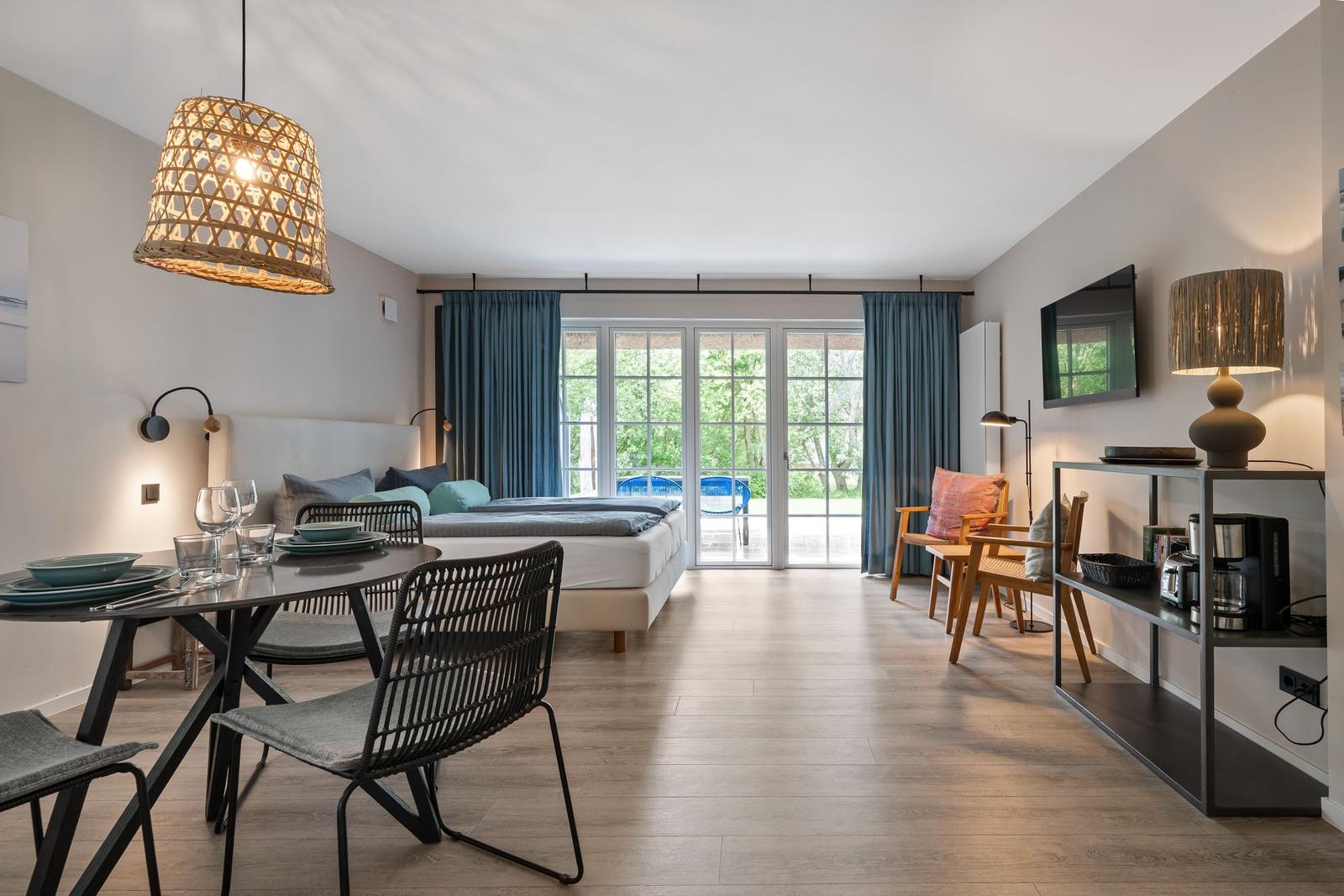Schlafzimmer mit Essbereich und Balkonzugang. Moderne Einrichtung und Holzboden.