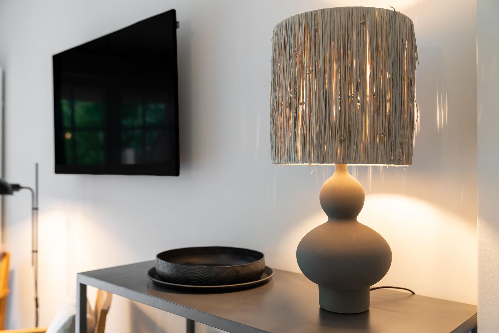 Tisch mit Laterne und Schale vor Wandfernseher