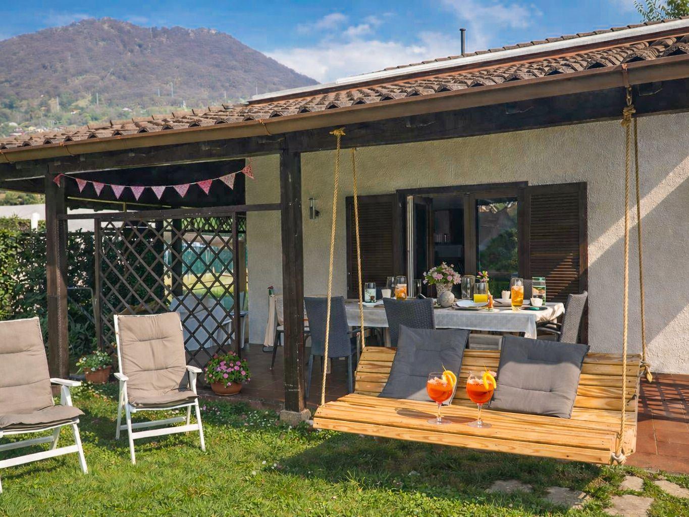 große Terrasse mit gepflegtem Garten und Hollywoodschaukel