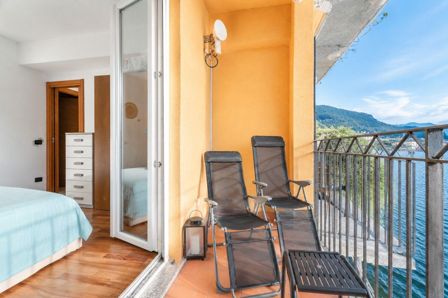 sonniger überdachter Balkon mit Liegestühlen