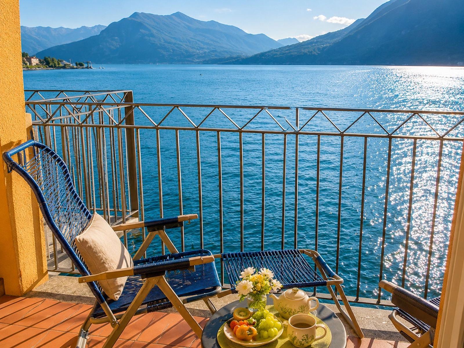 Balkon mit Stuhl und Tisch, Blick auf See und Berge.