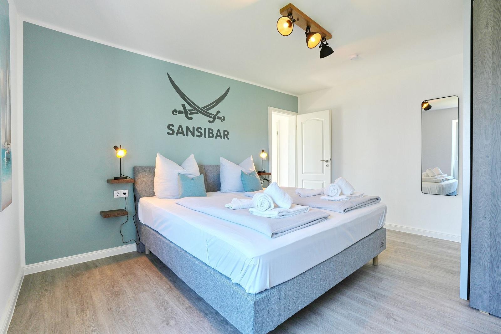 Schlafzimmer mit Bett, Wanddekoration und Spiegel