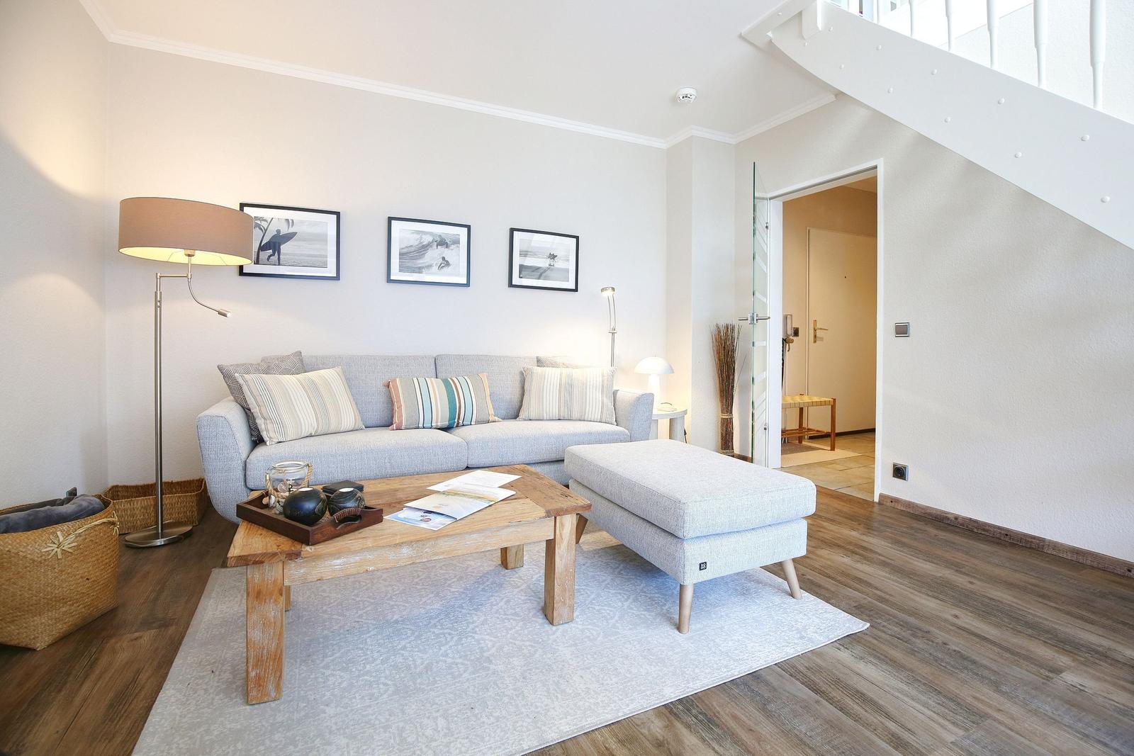 Wohnzimmer mit Sofa, Couchtisch und Treppenaufgang