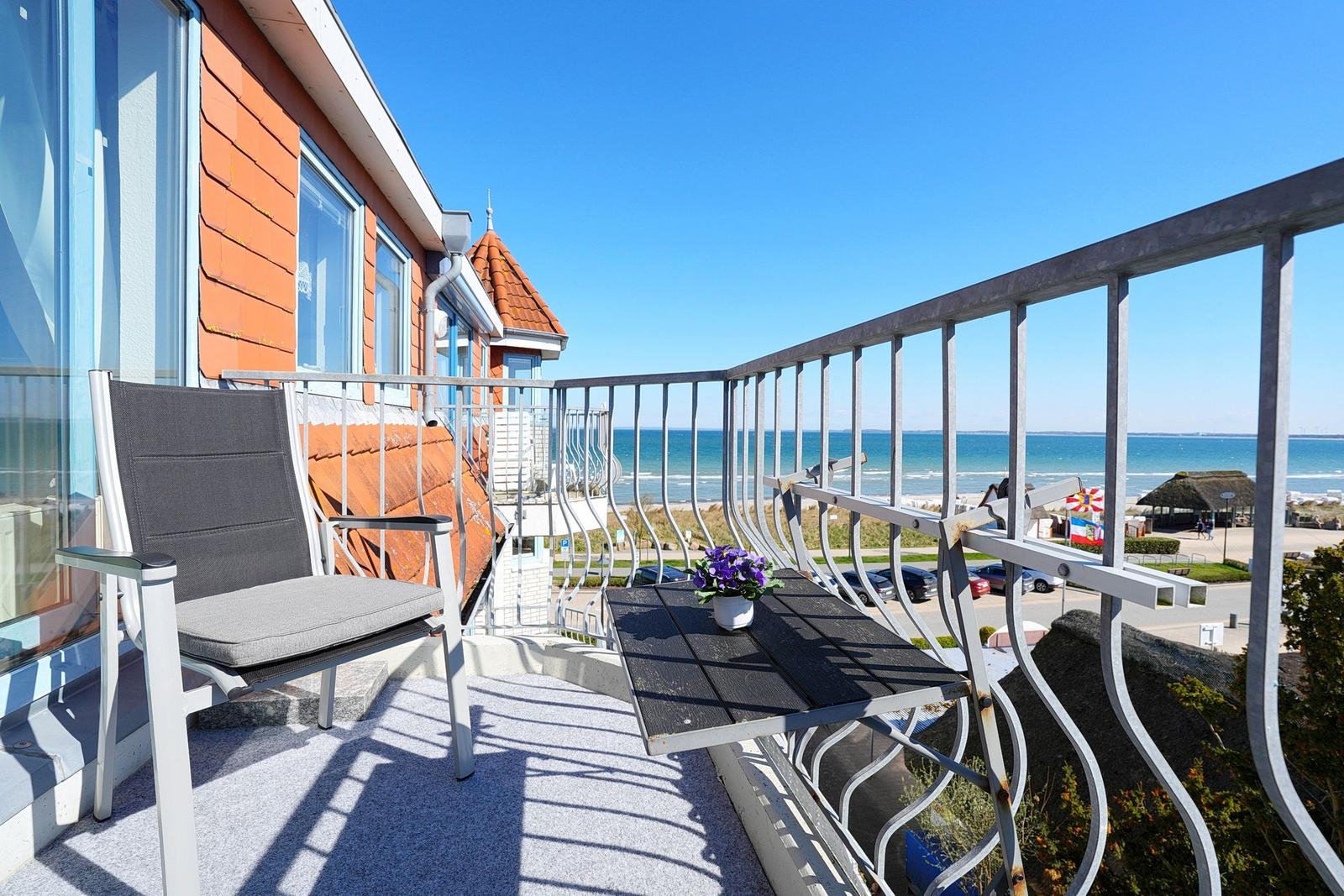 Balcony with chair and table overlooking the sea.