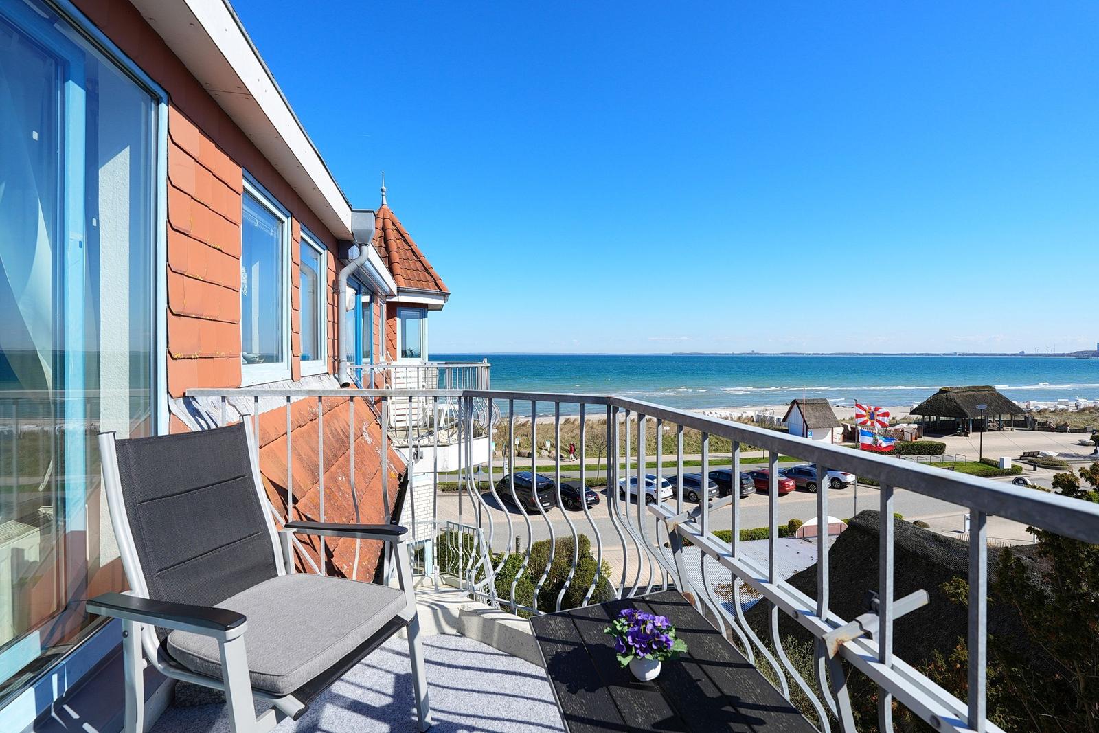 Terrasse mit Sitzgelegenheit und Blick auf das Meer und Strand.
