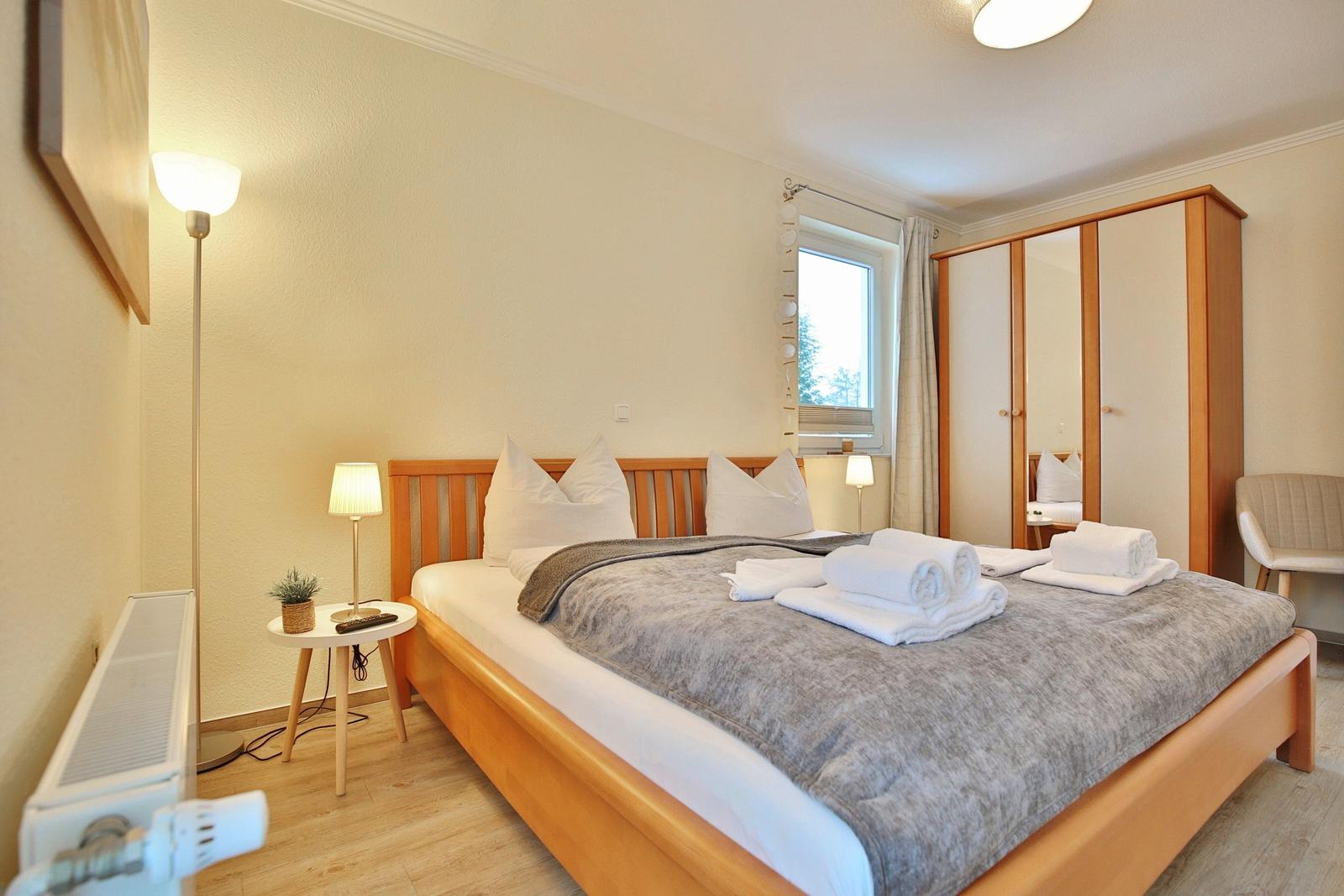 Bedroom with bed, wardrobe, and window.