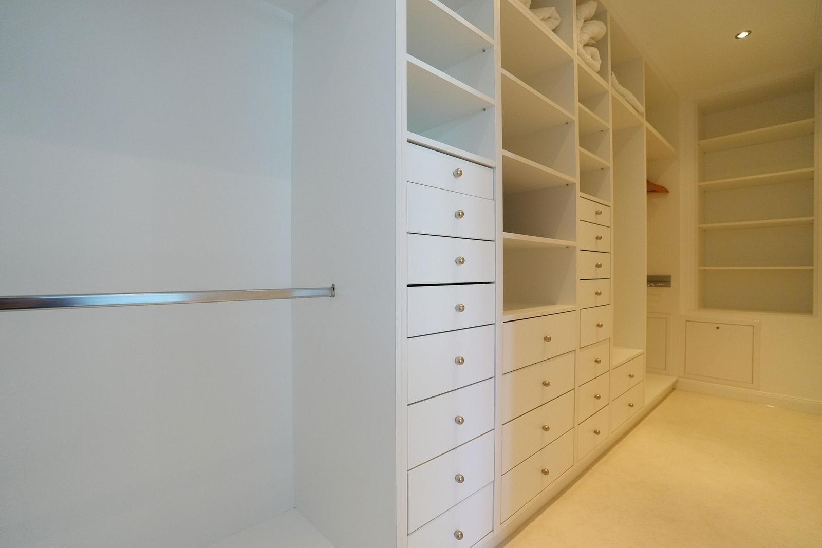 Großer Kleiderschrank mit Schubladen und Regalen. Metallstange für Kleidung.